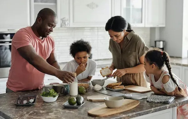 Family preparing food together in a bright kitchen.