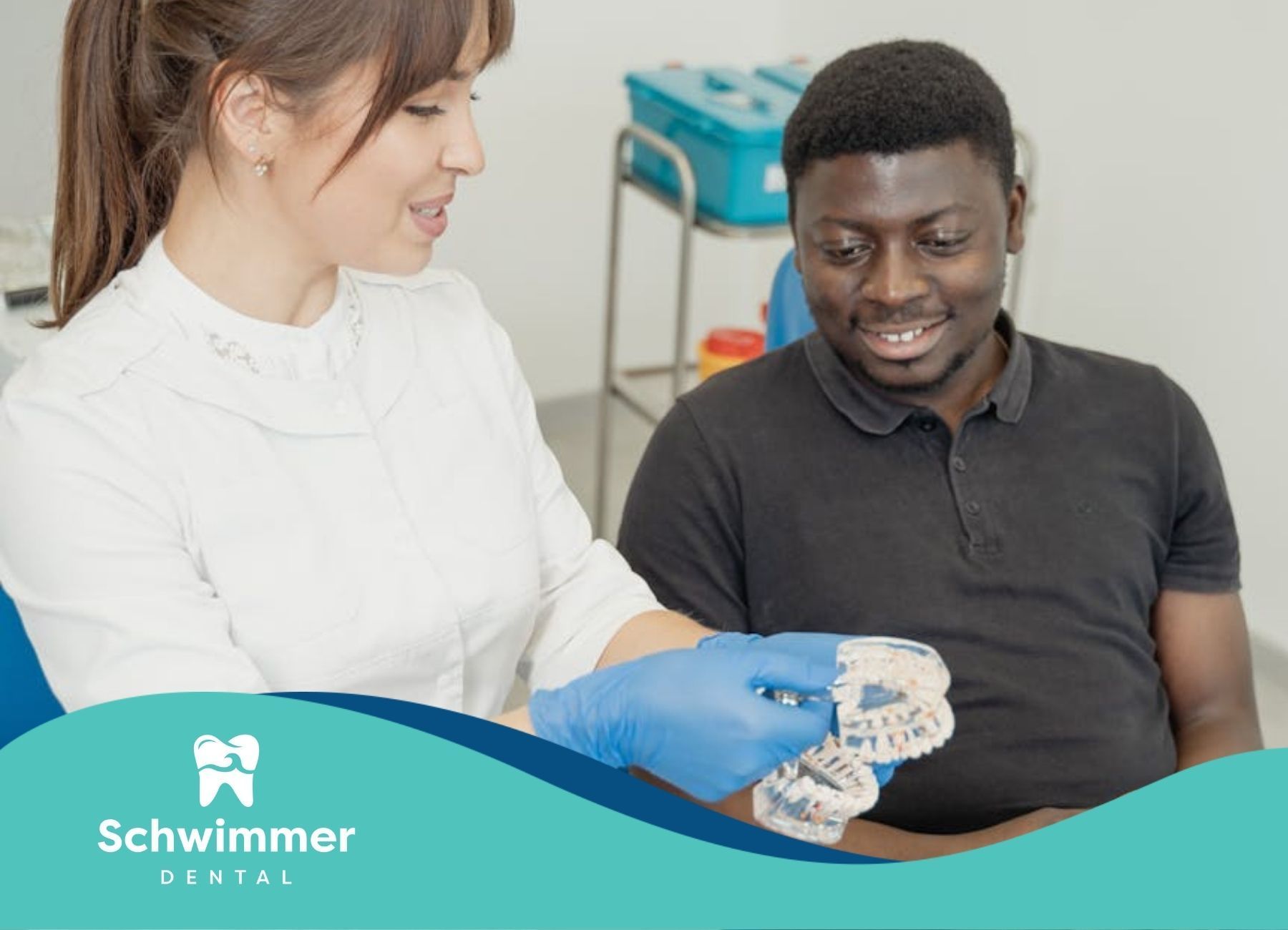 Dentist explaining the dental implant model to a male patient at a dental clinic in New Jersey.