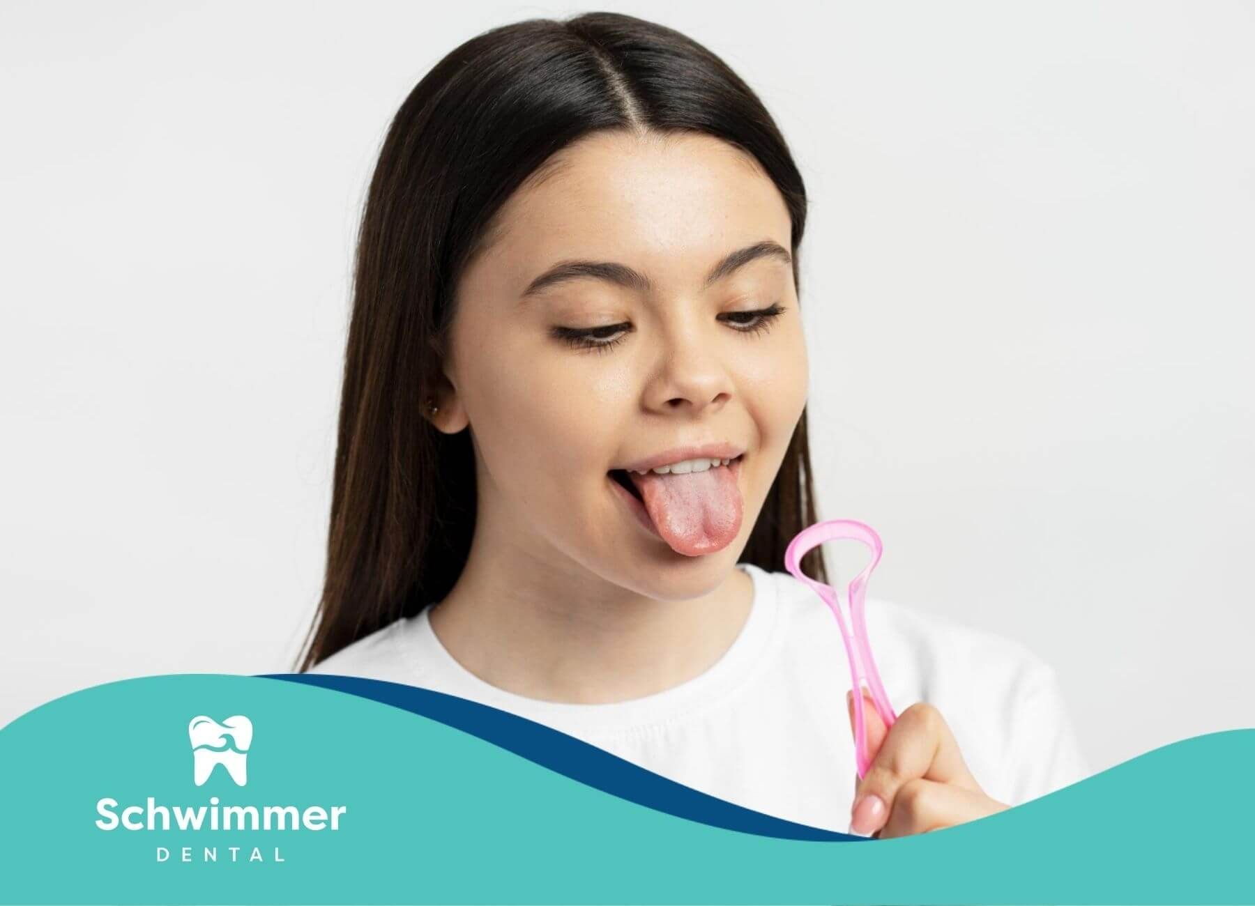 Woman using pink tongue scraper for oral hygiene.