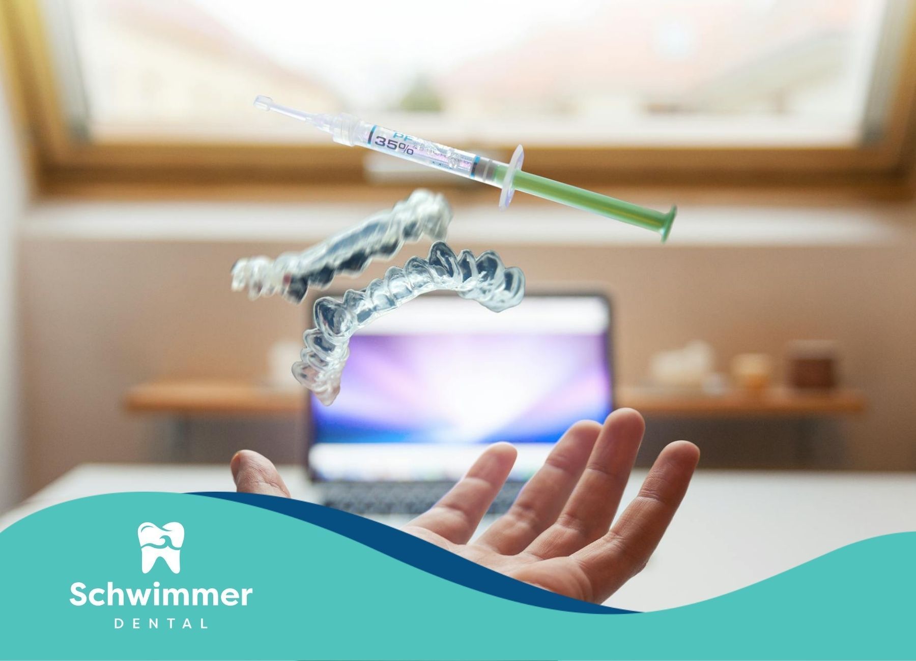 The dentist hand tossing dental aligners and syringe in front of a blurred laptop in New Jersey.
