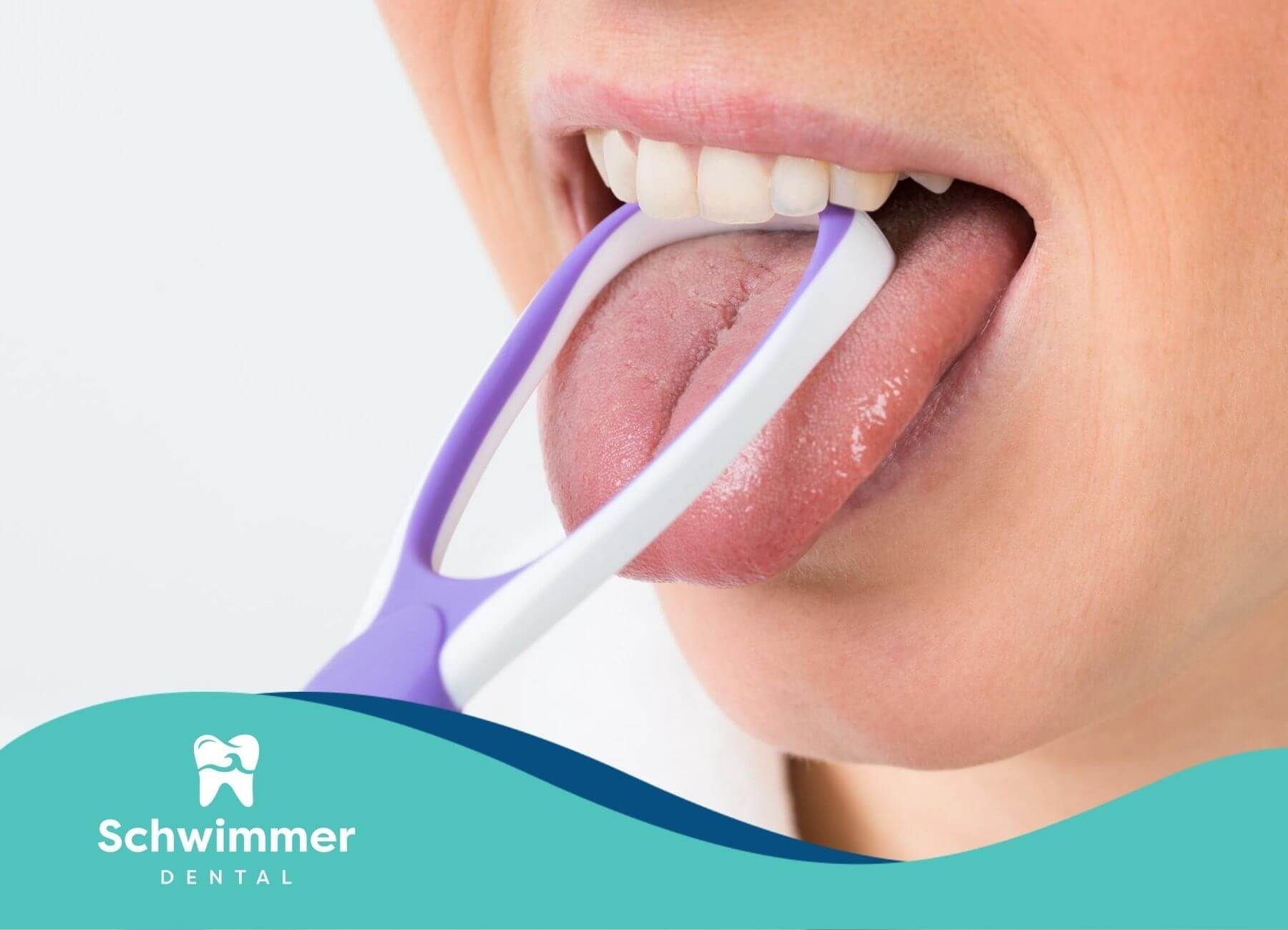 A person is cleaning their tongue with a tongue scraper.