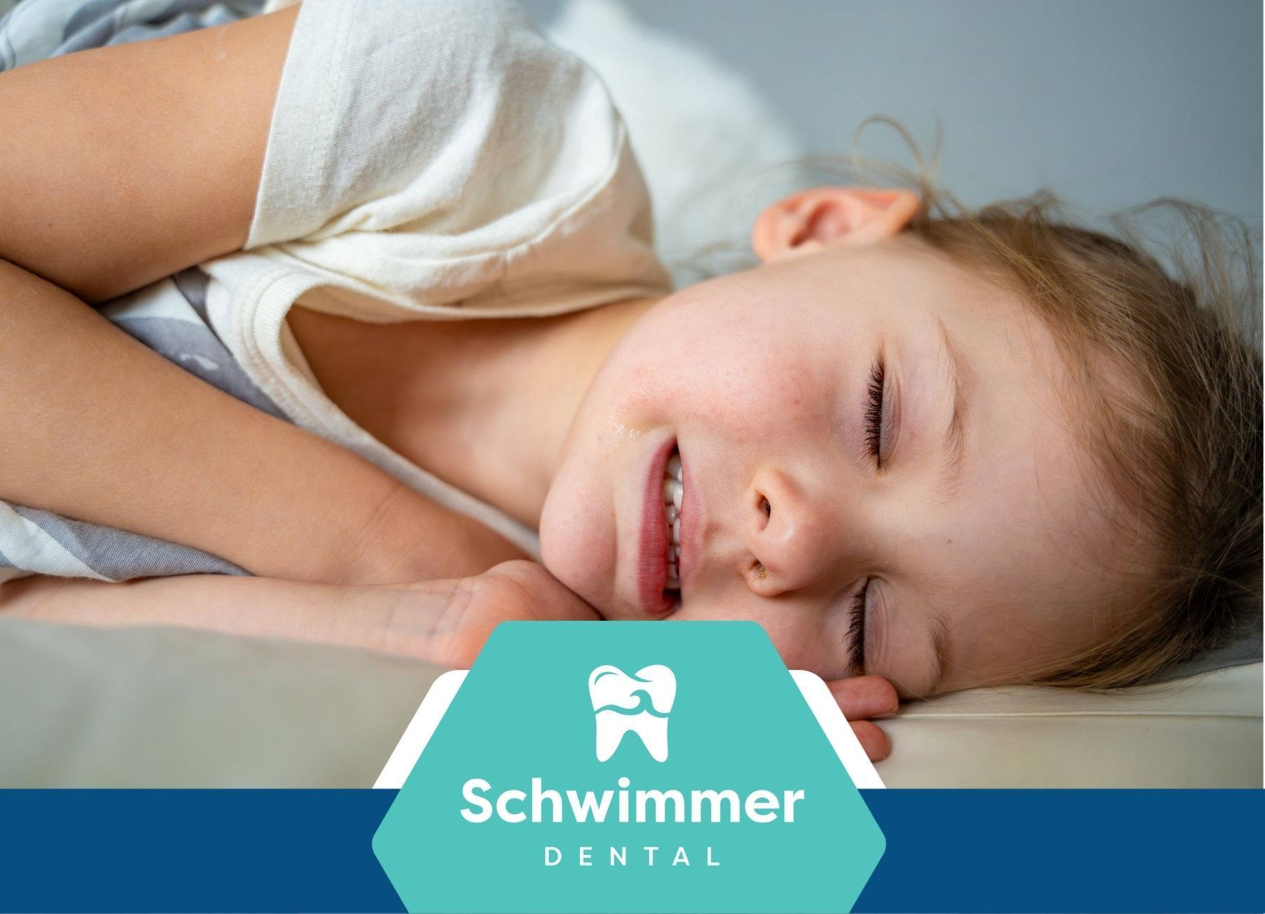A little girl is sleeping on a bed with her eyes closed.