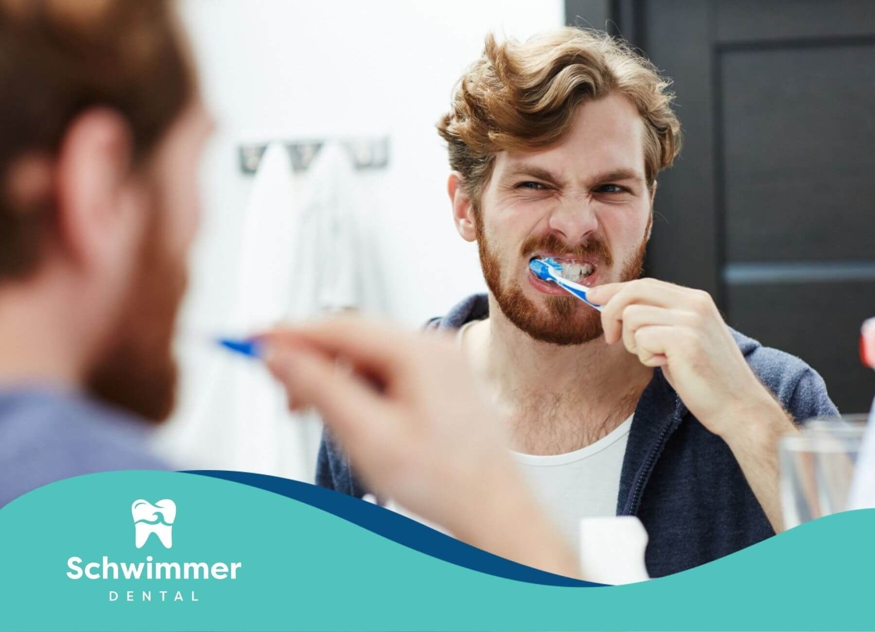 Man brushing teeth aggressively in a mirror.