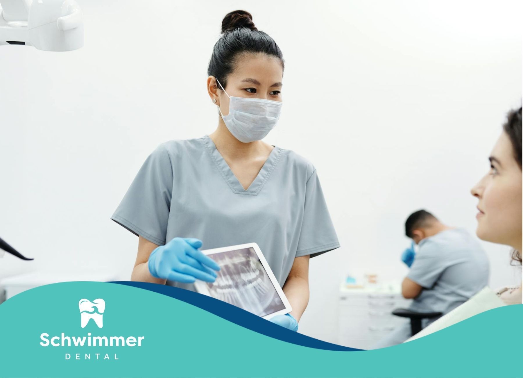 A dentist showing a dental X-ray on a tablet to a patient at a clinic in Point Pleasant Beach, NJ.