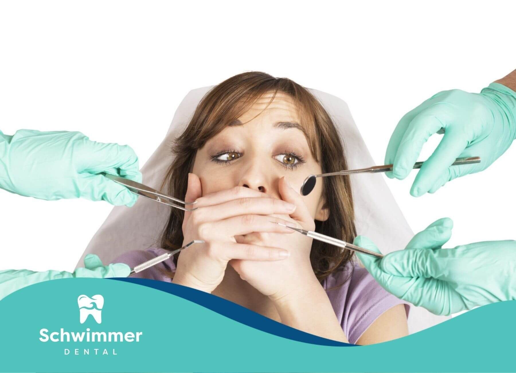 A woman is covering her mouth while being examined by a dentist.