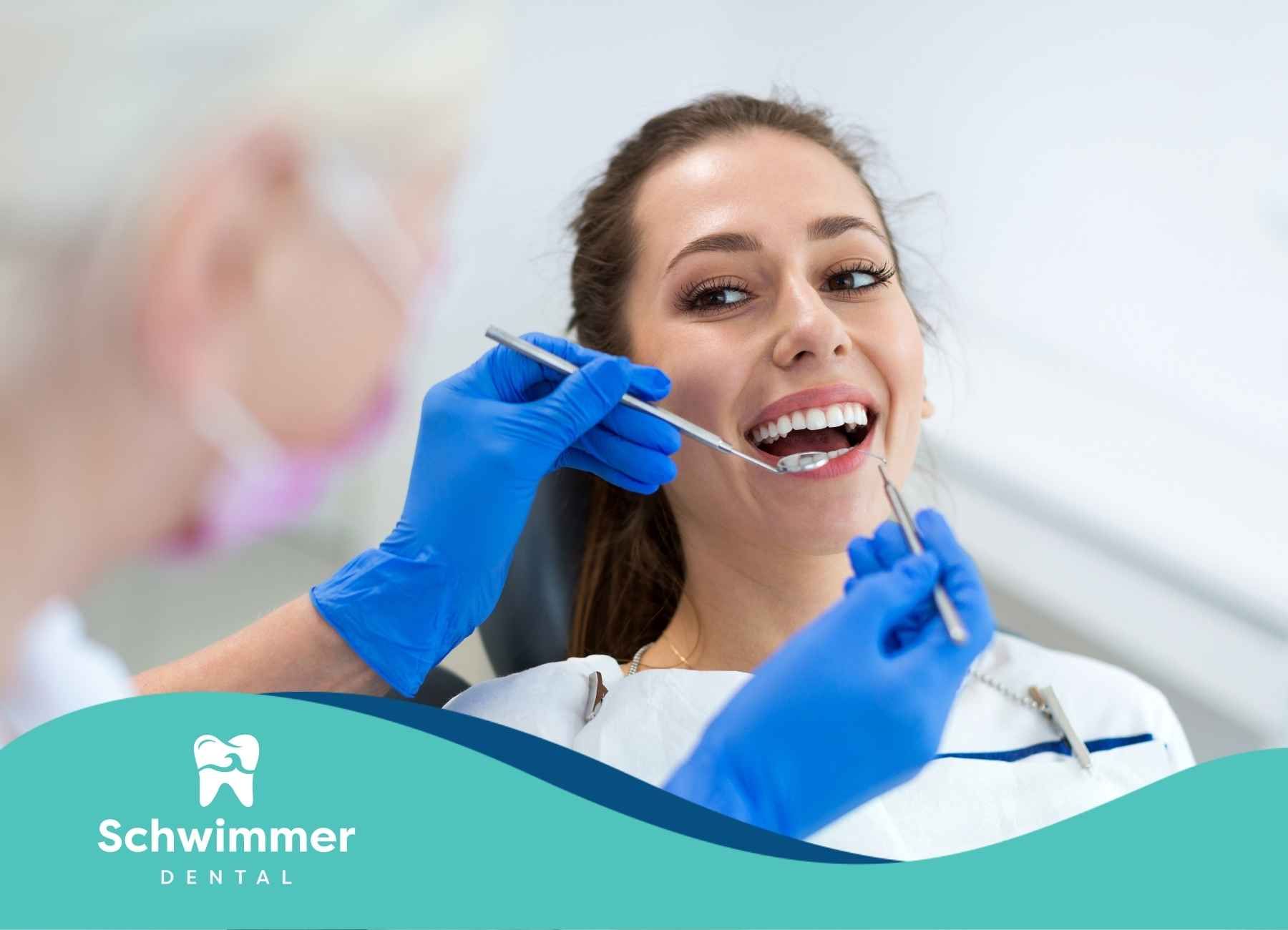 A woman is getting her teeth examined by a dentist.