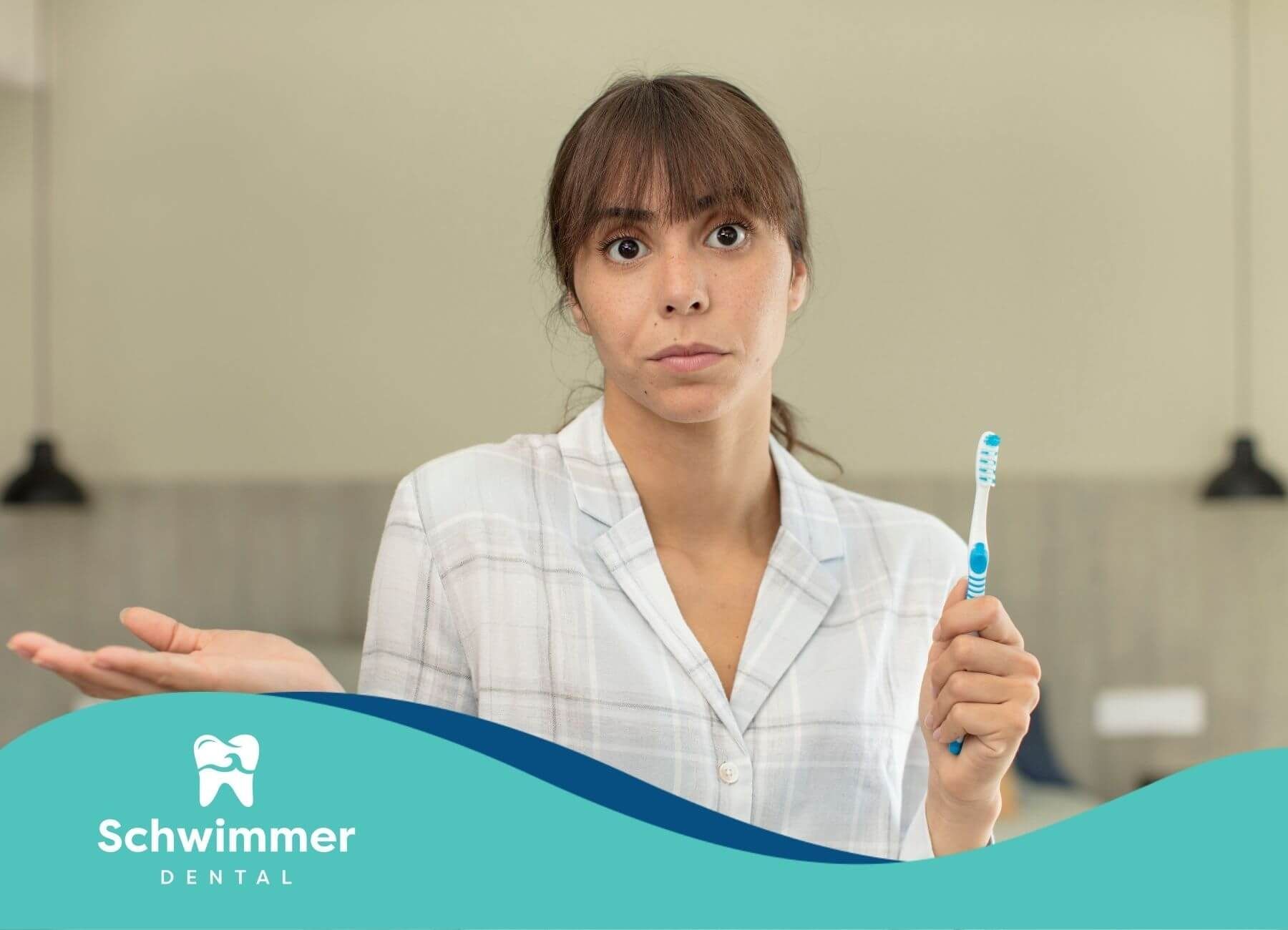 Woman holding a toothbrush with a confused expression, representing uncertainty about proper hygiene