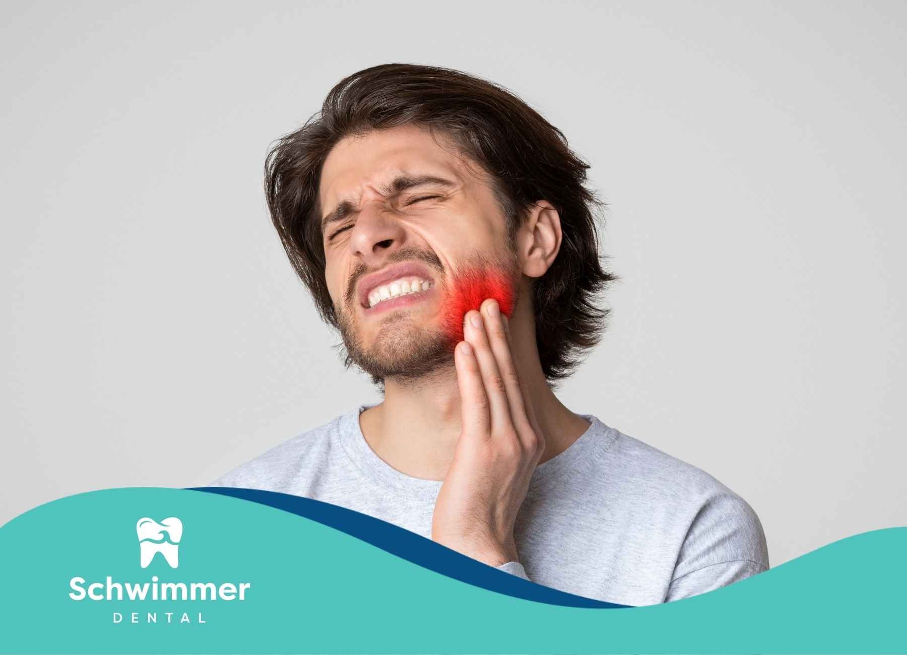 Man with pained expression, holding jaw. Red highlight indicates tooth pain.