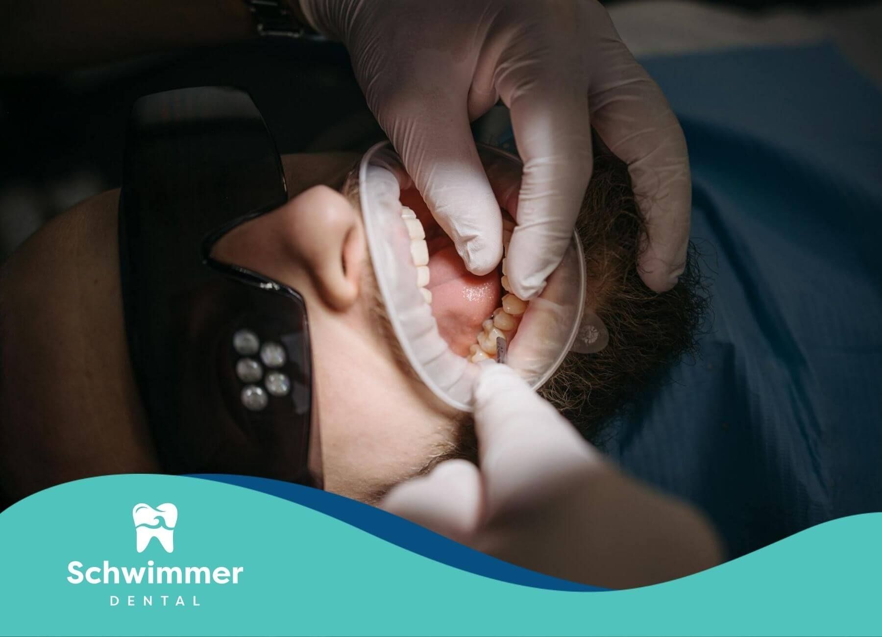 A female dentist carefully examines a patient’s teeth and gums using professional dental tools.