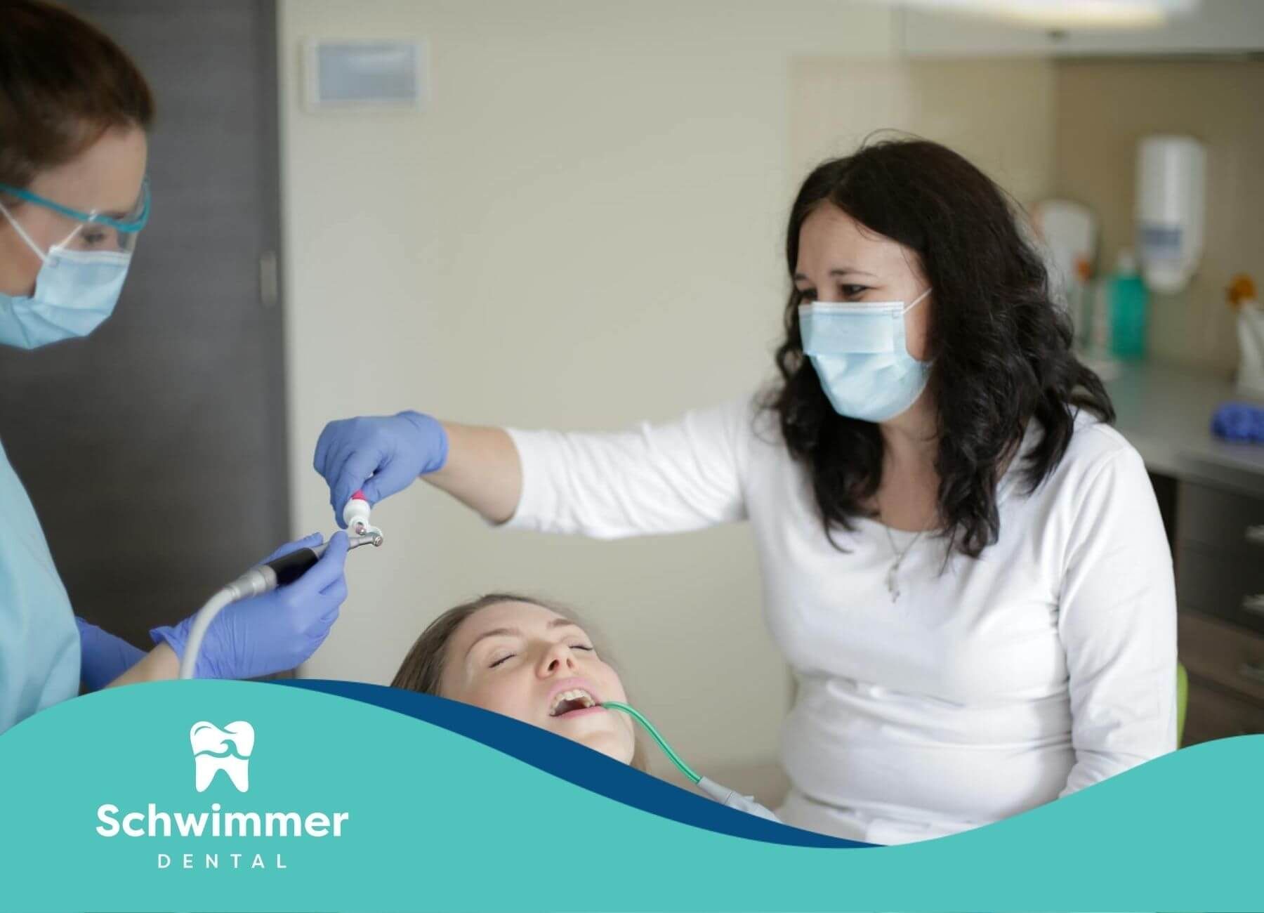Two female dental professionals performing a dental procedure on a female patient in New Jersey.