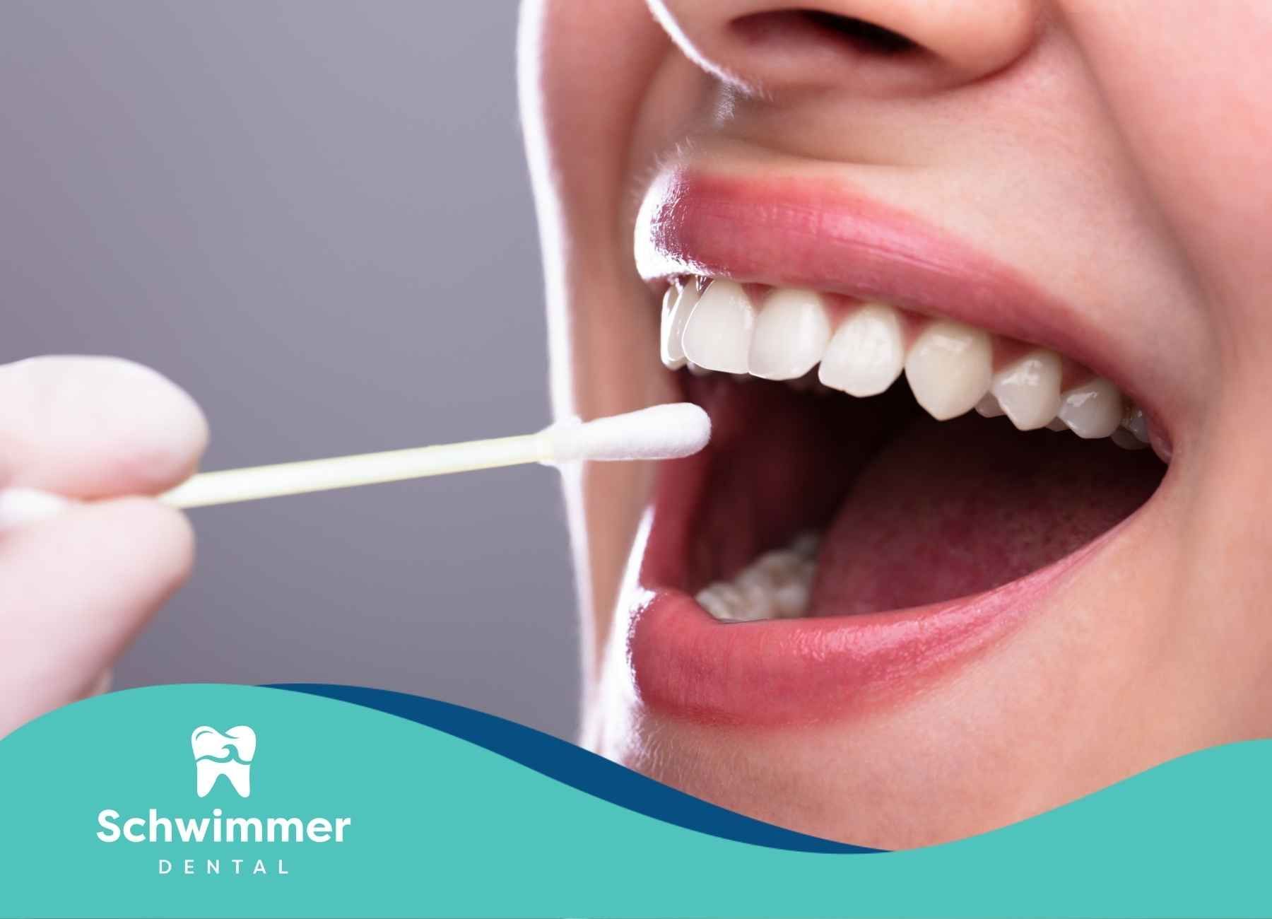 A woman is getting her teeth examined by a dentist at schwimmer dental