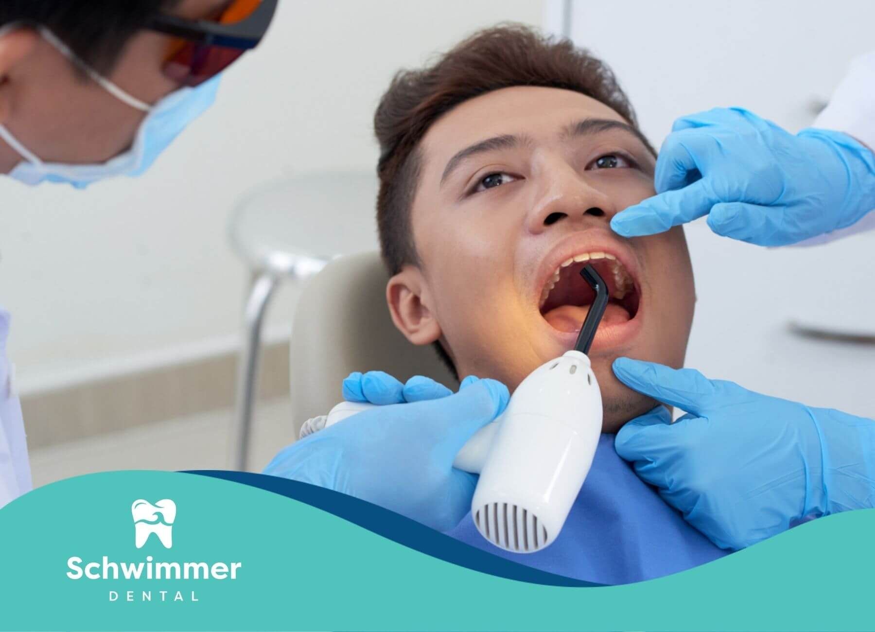 A man is getting his teeth examined by a dentist.