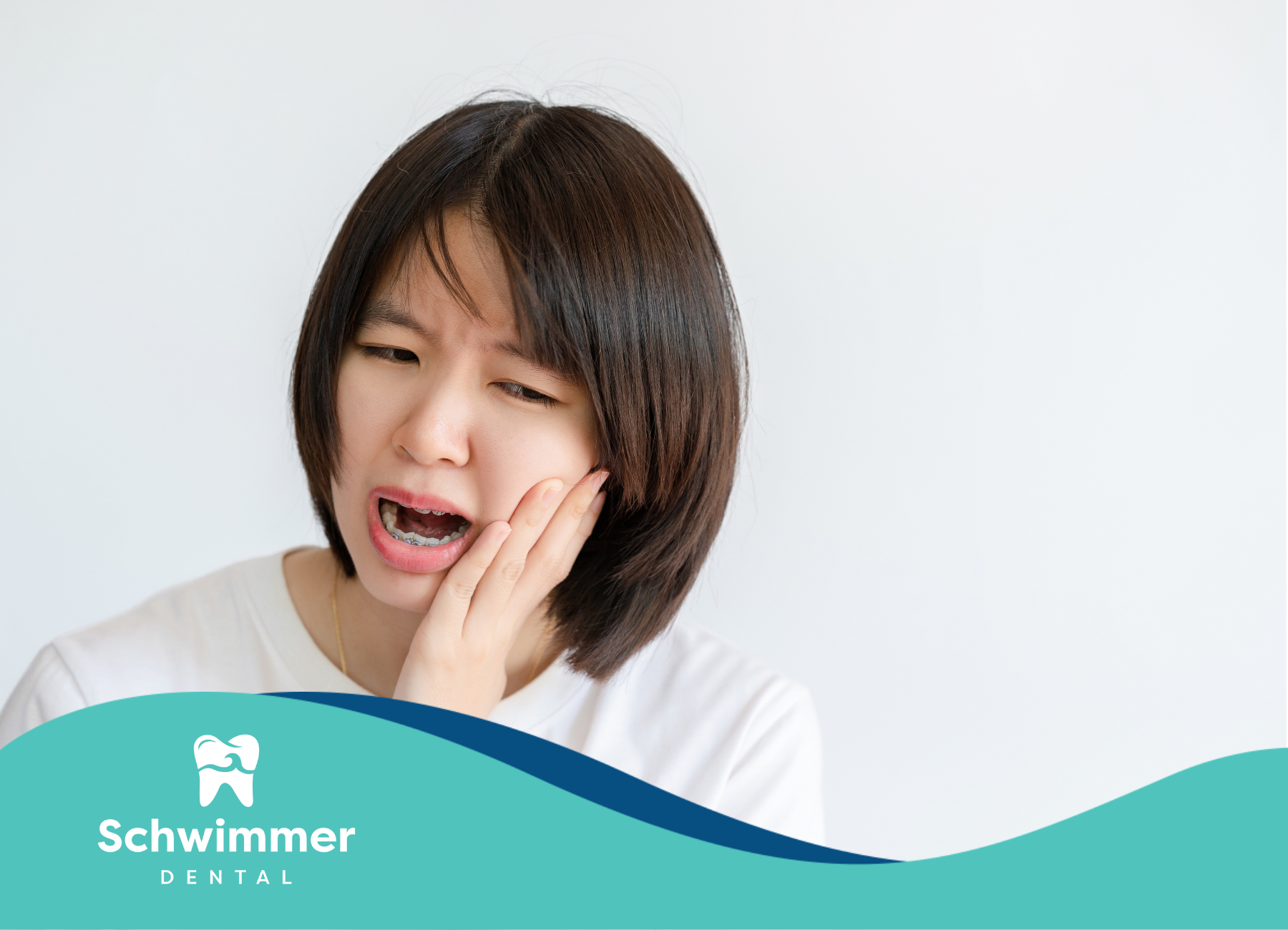 A woman is holding her mouth in pain because of a toothache.