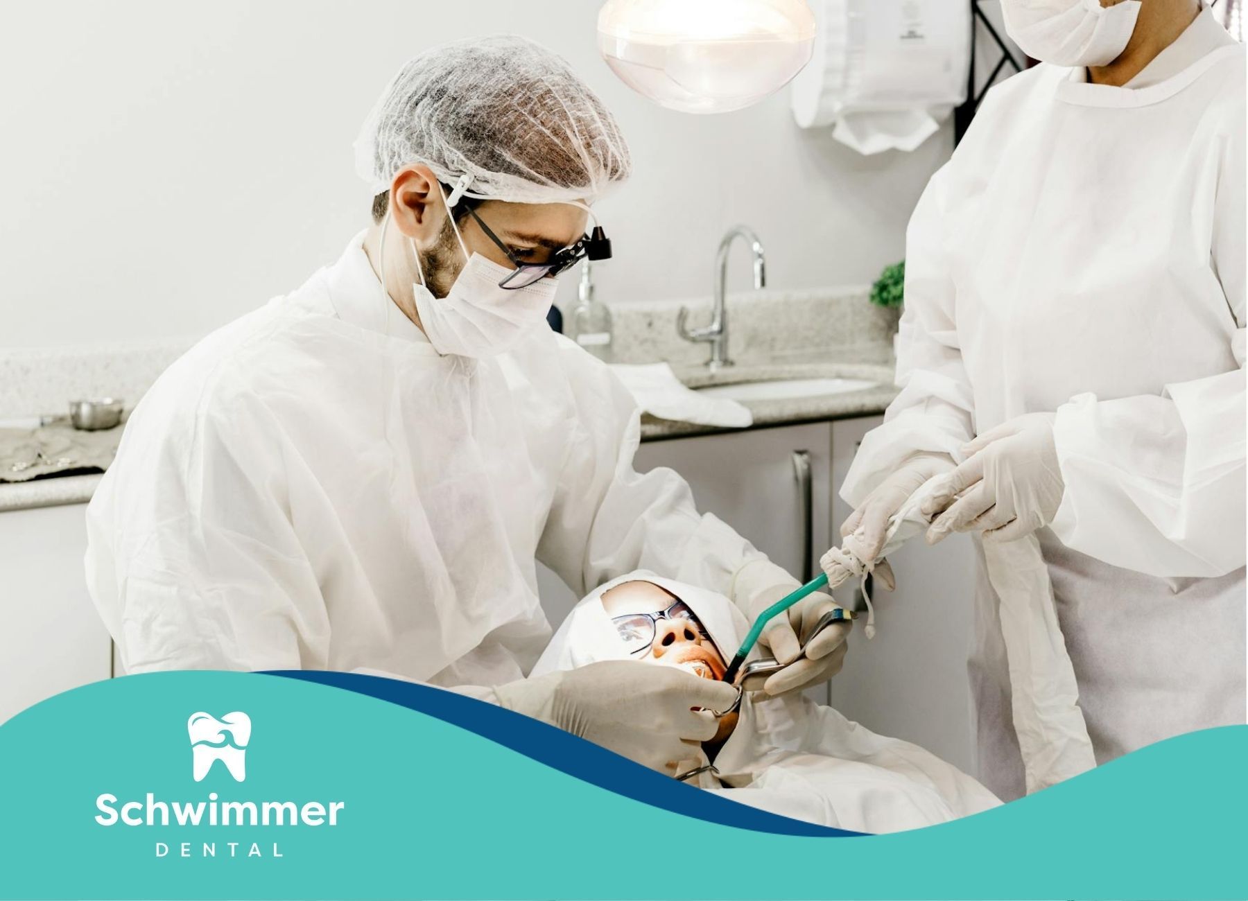 Dentist and assistant in protective gear performing a procedure on a patient in Point Pleasant, NJ.