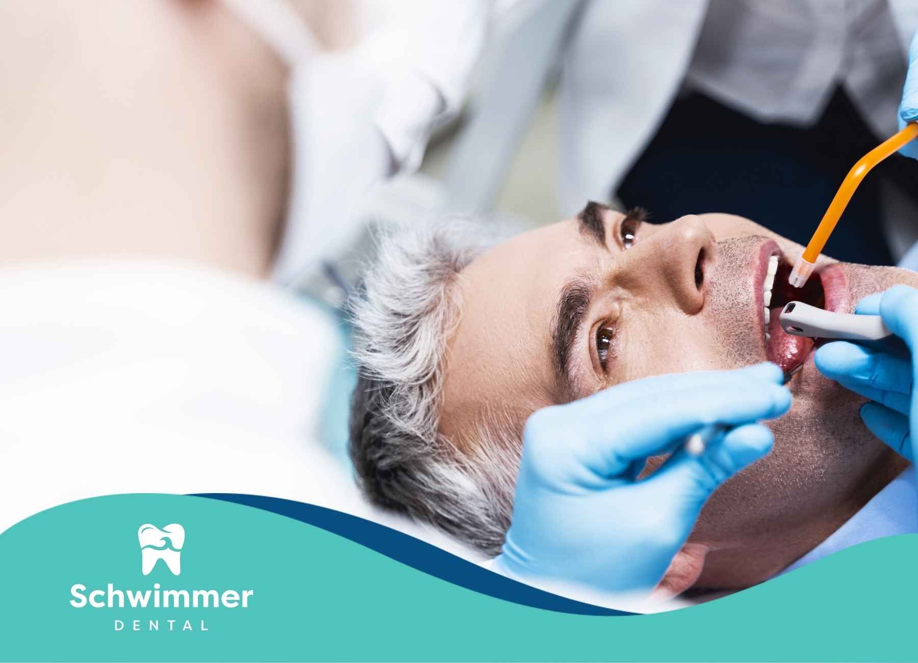 Dentist treating a patient's teeth. Hands in blue gloves, mouth open, dental tools in use.