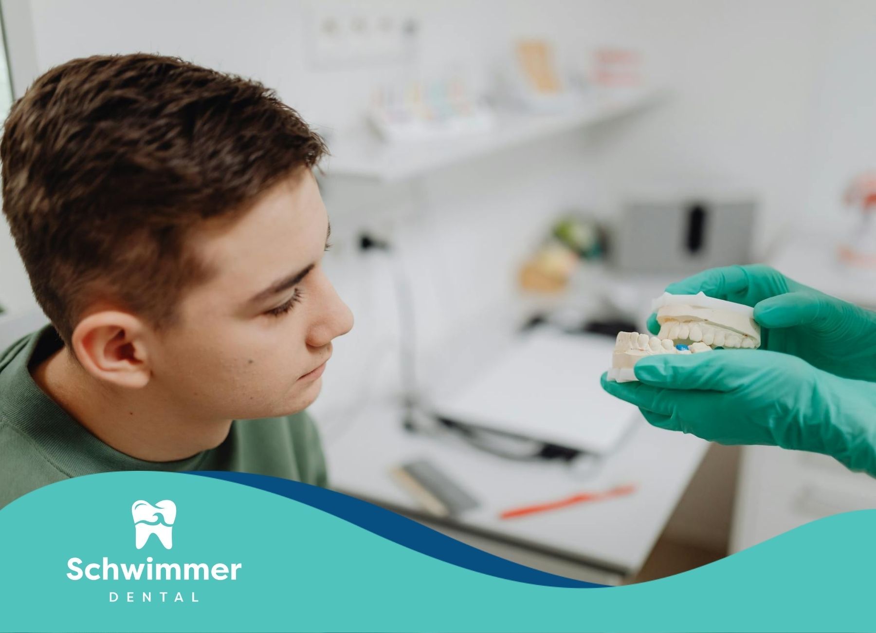 Dentist showing teen a dental implant model of teeth during his checkup at a dental clinic in NJ.