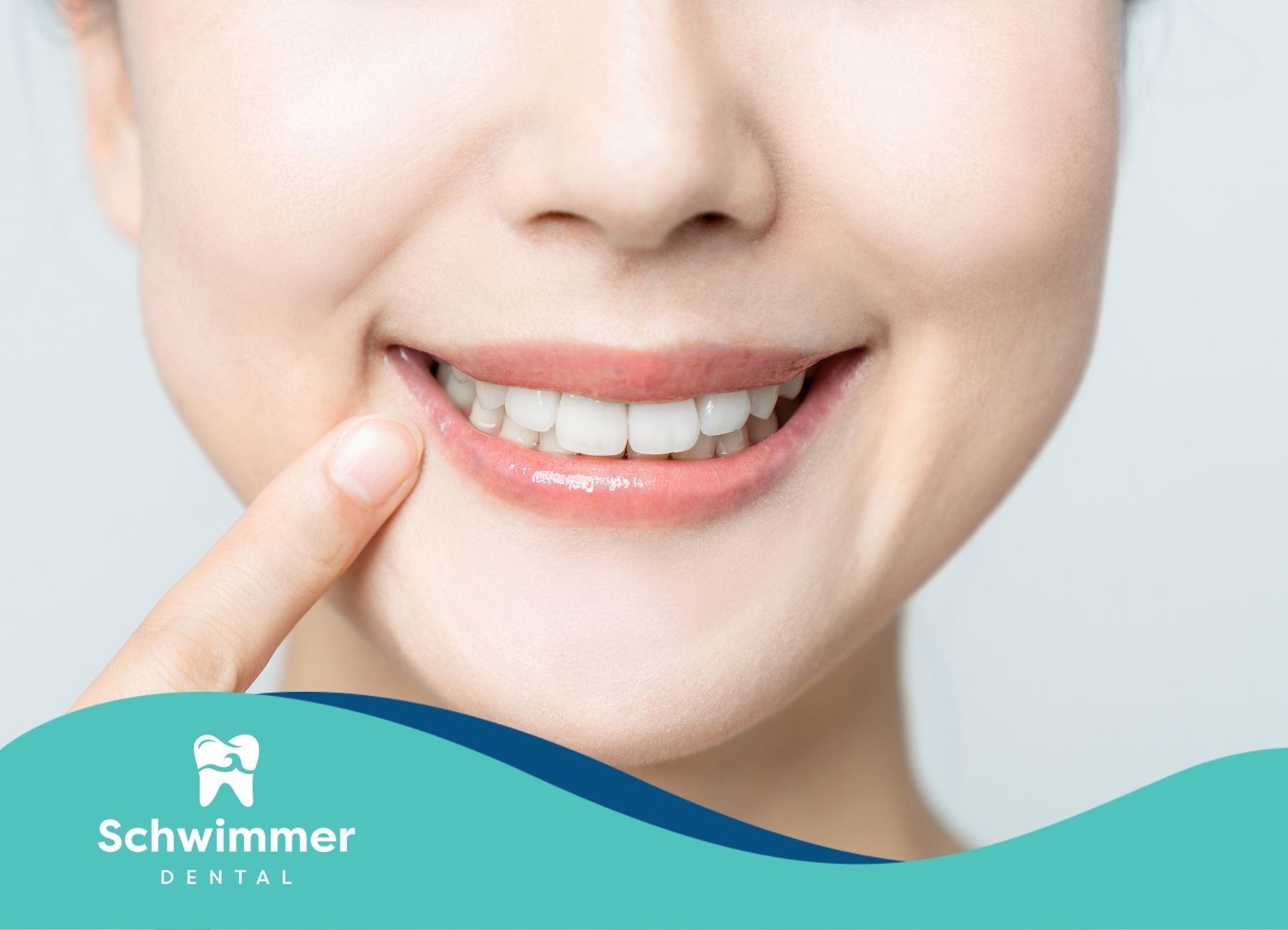 Woman smiles, finger pointing to teeth. Bright white teeth, light skin, blue banner.