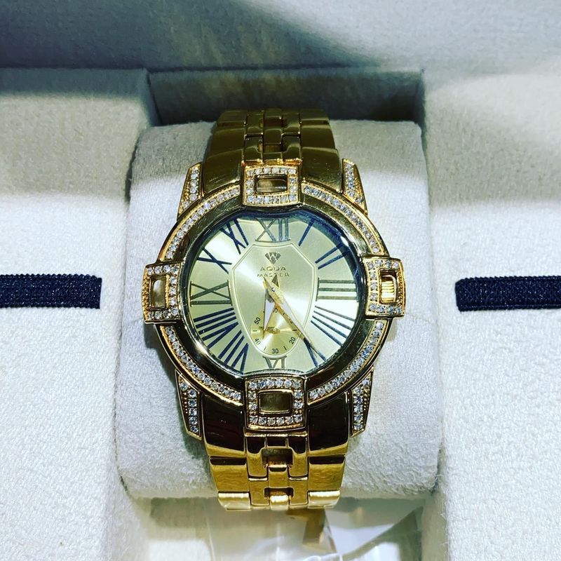 A gold watch with roman numerals on the face