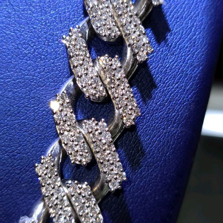 A close up of a diamond chain on a blue surface