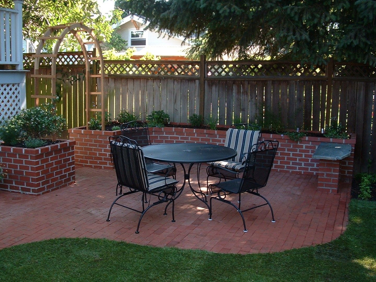 A patio with a table and chairs in the backyard