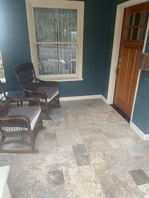 A porch with rocking chairs and a window