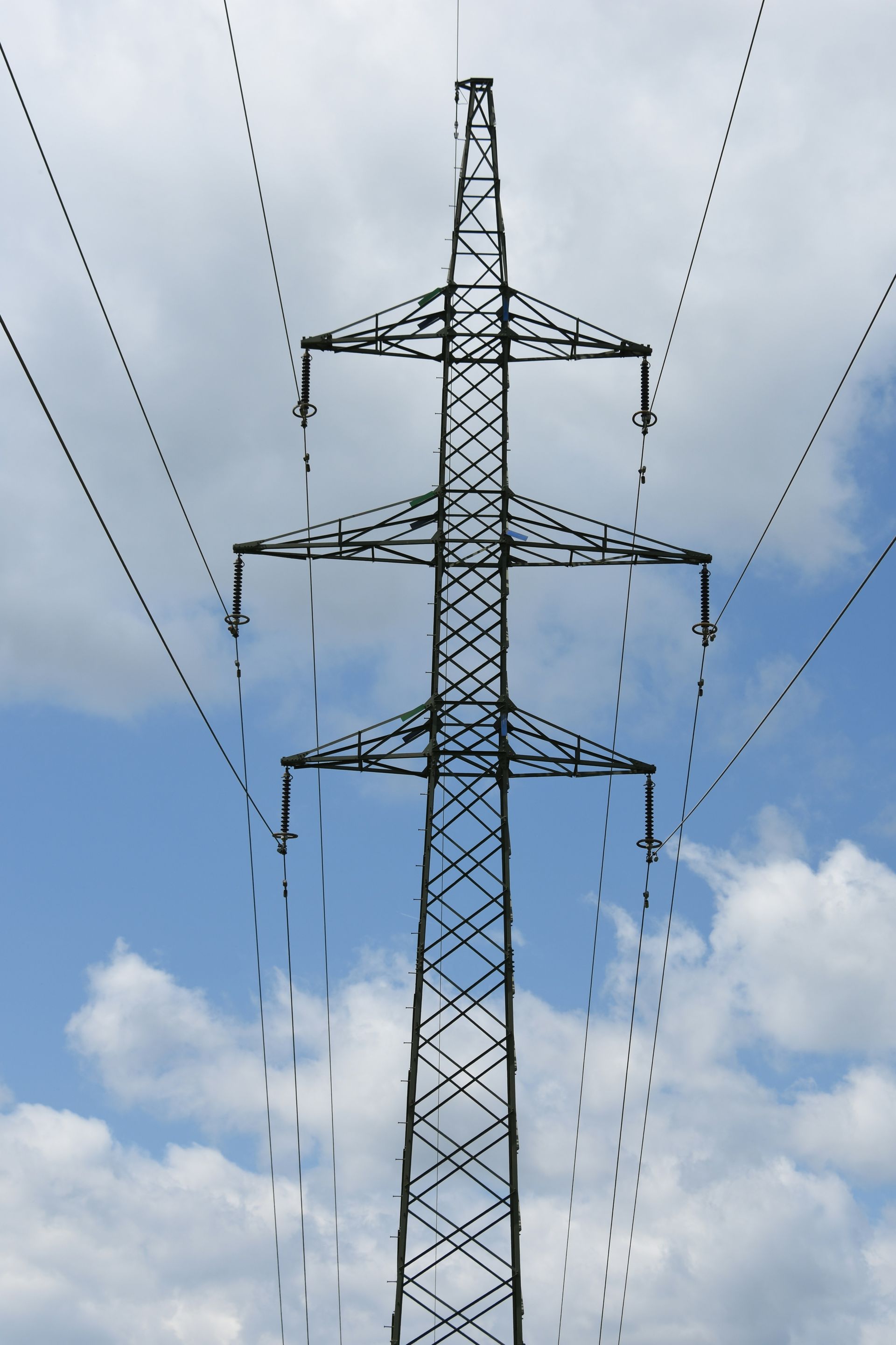 Power Line Tower Against a Partly Cloudy Blue Sky — Bennett's Tree Service in Lake Macquarie, NSW