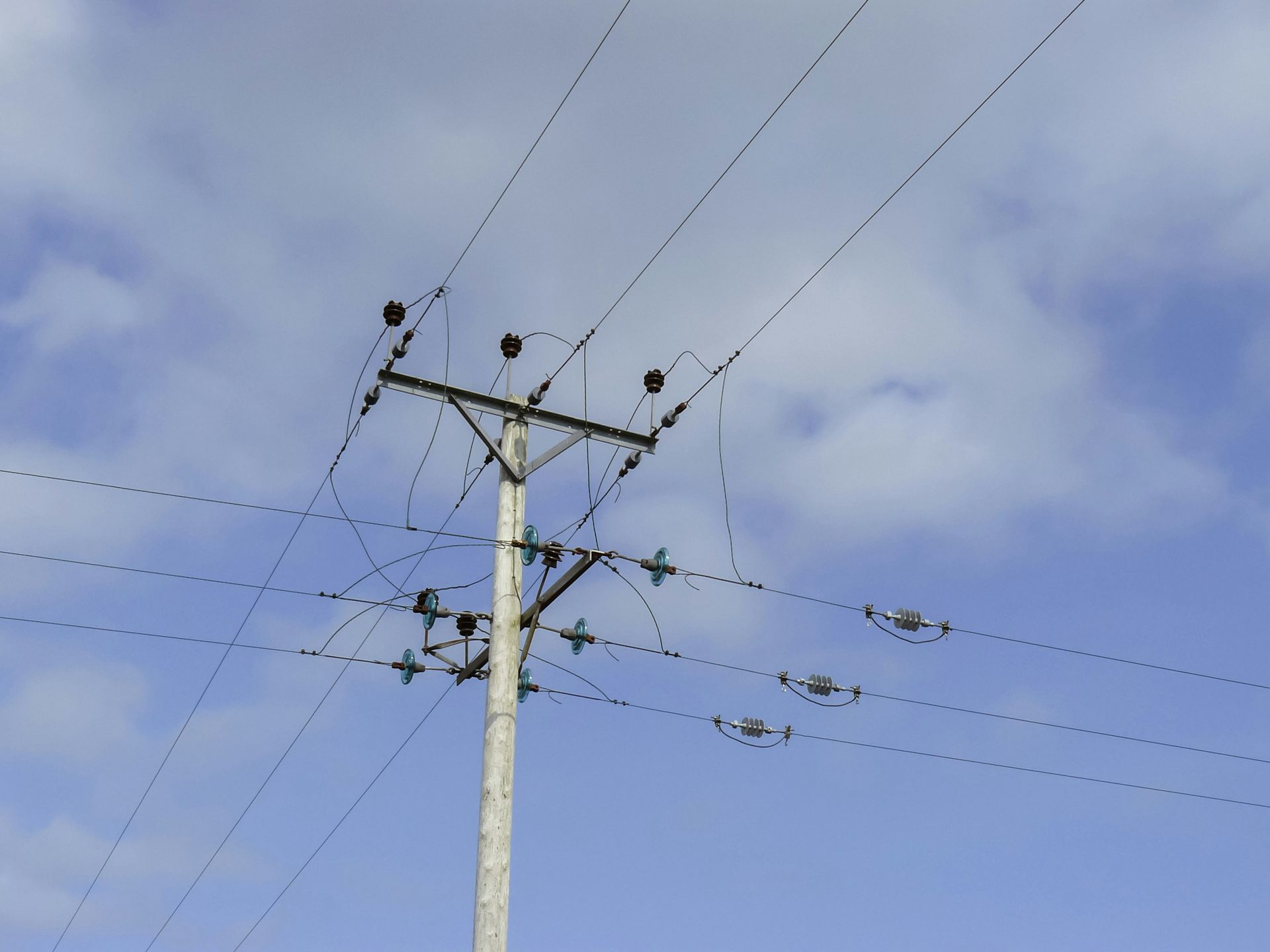 Power Lines and Utility Pole Against a Cloudy Blue Sky — Bennett's Tree Service in Lake Macquarie, NSW
