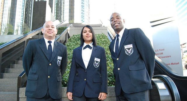 Three people in suits and ties are standing next to each other