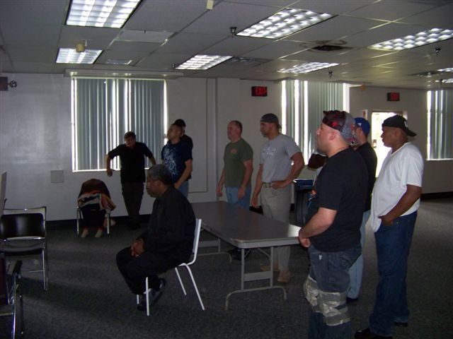 A group of men are standing around a table in a room