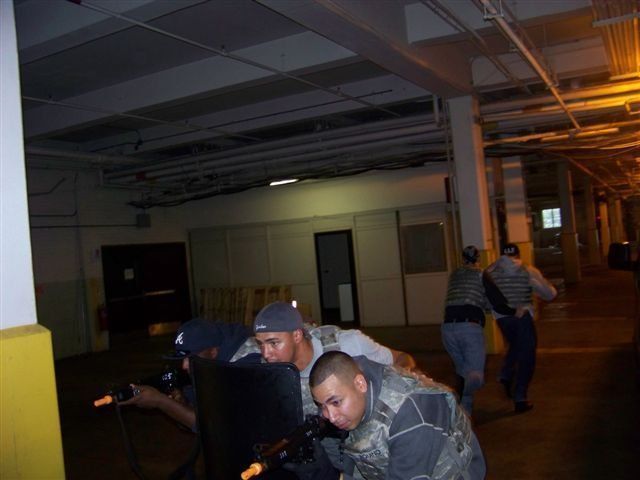 A group of men are standing in a dark hallway