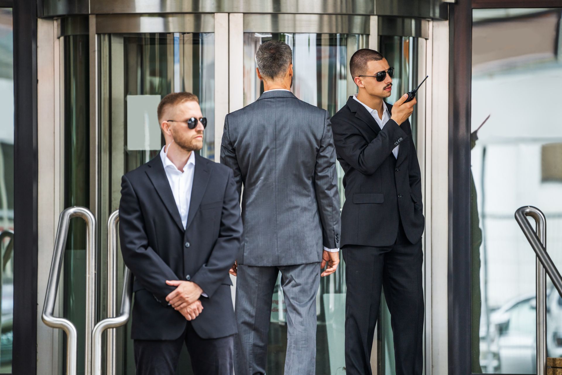 A group of men in suits are standing outside of a building.