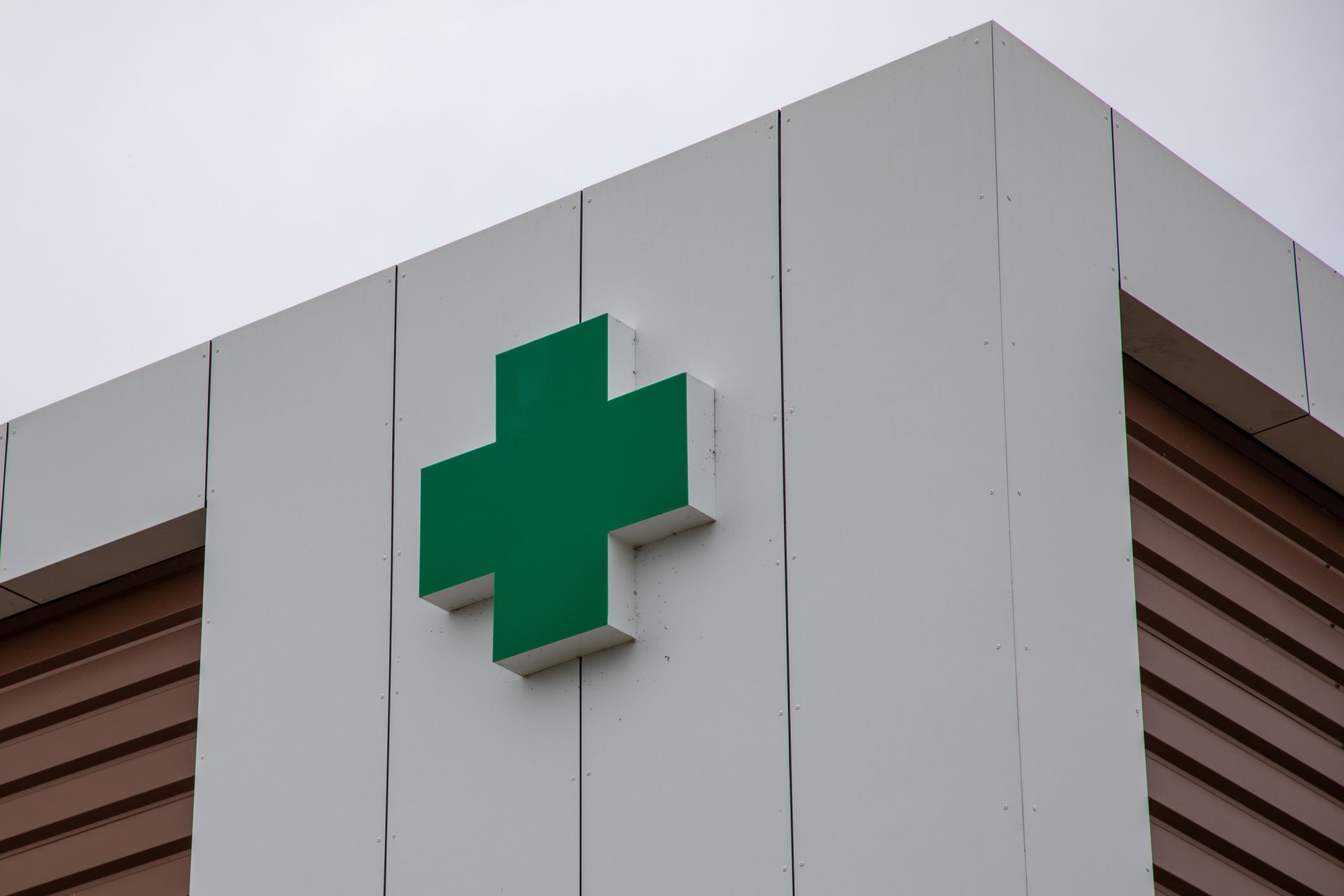 A green cross is on the side of a building.
