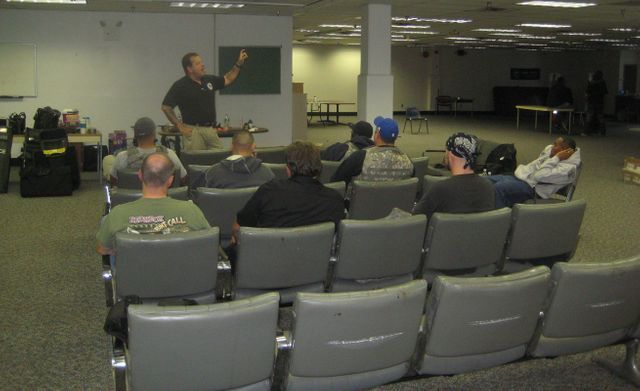 A man is giving a presentation to a group of people sitting in chairs