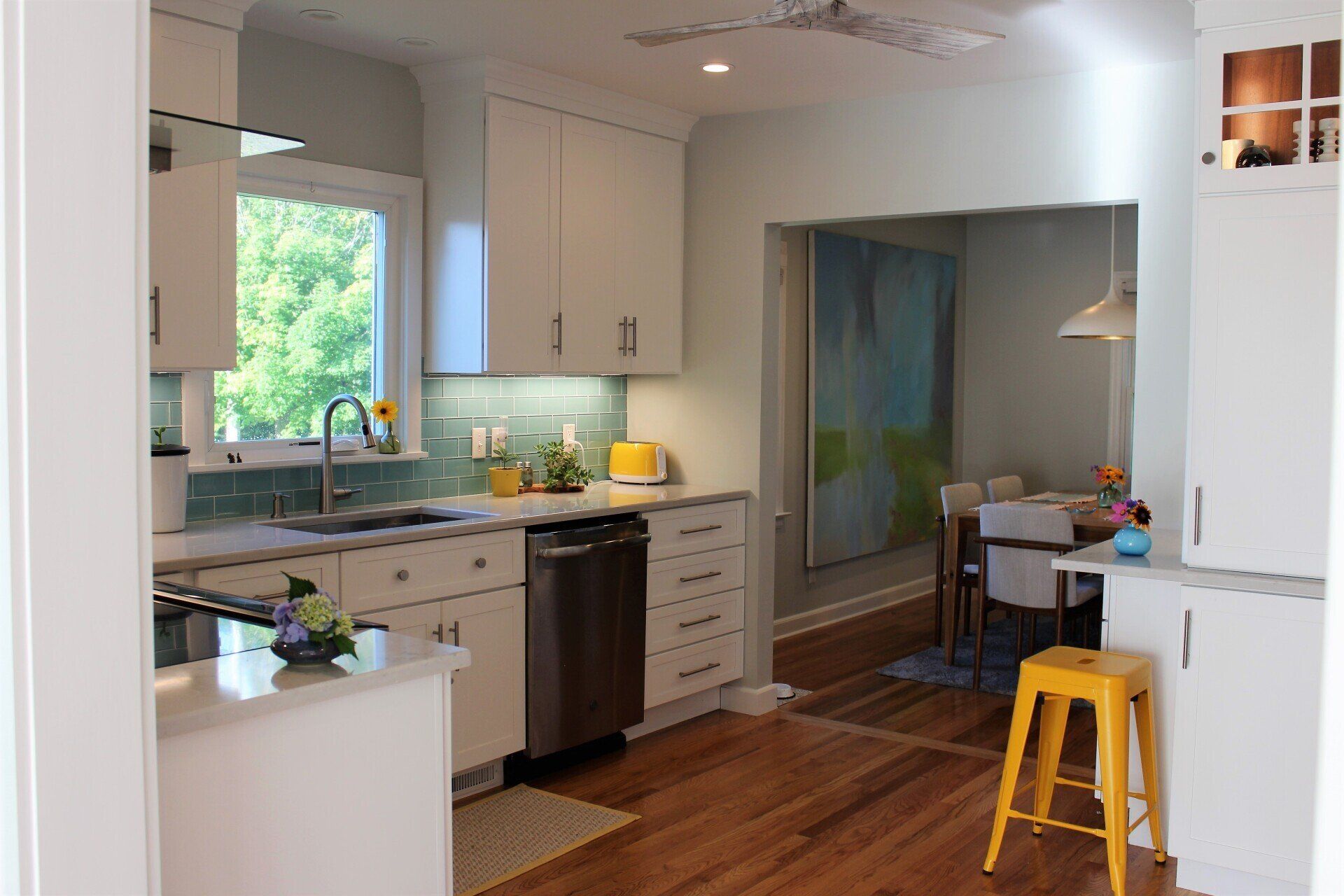 a kitchen with white cabinets and a yellow stool
