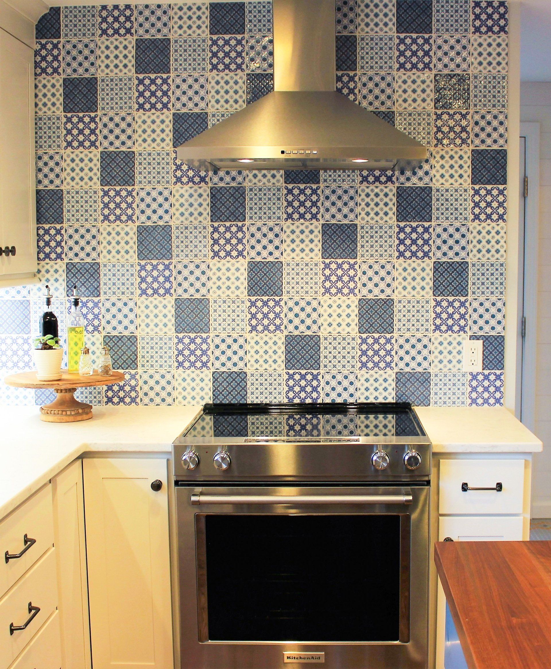 a kitchen with blue and white tiles and a kitchenaid stove