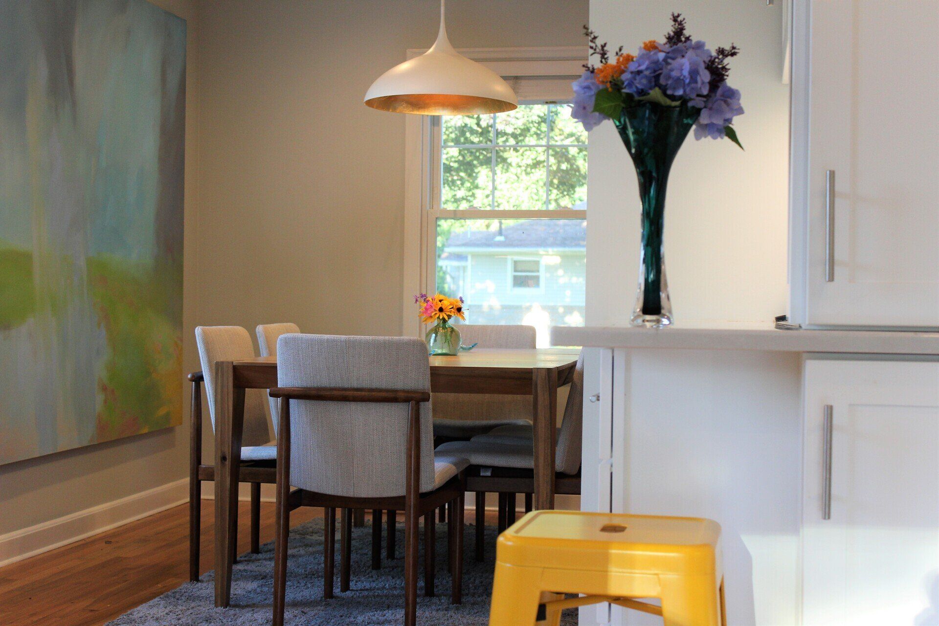 a dining room table with a vase of flowers on it