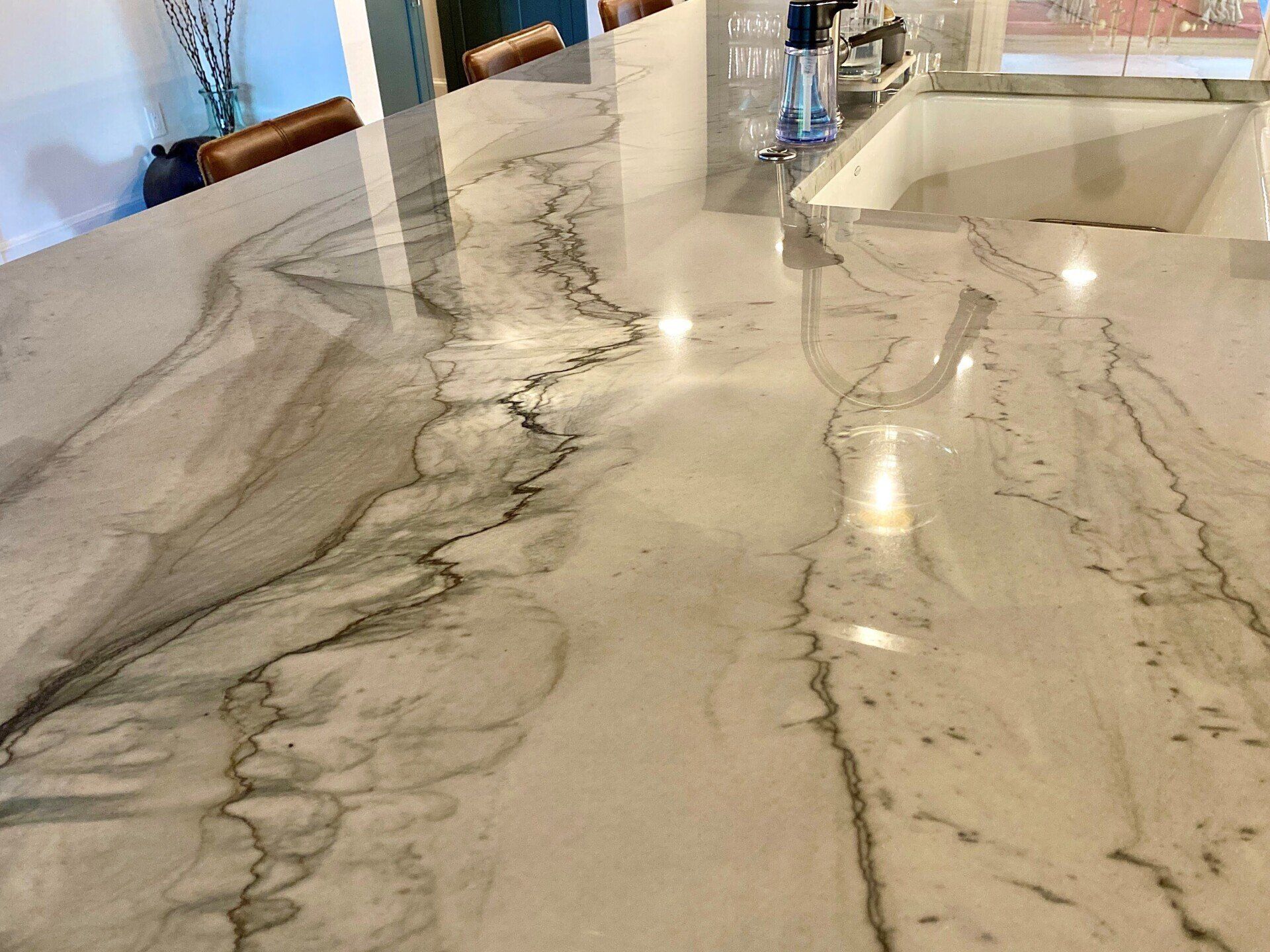 a marble counter top with a sink in the background