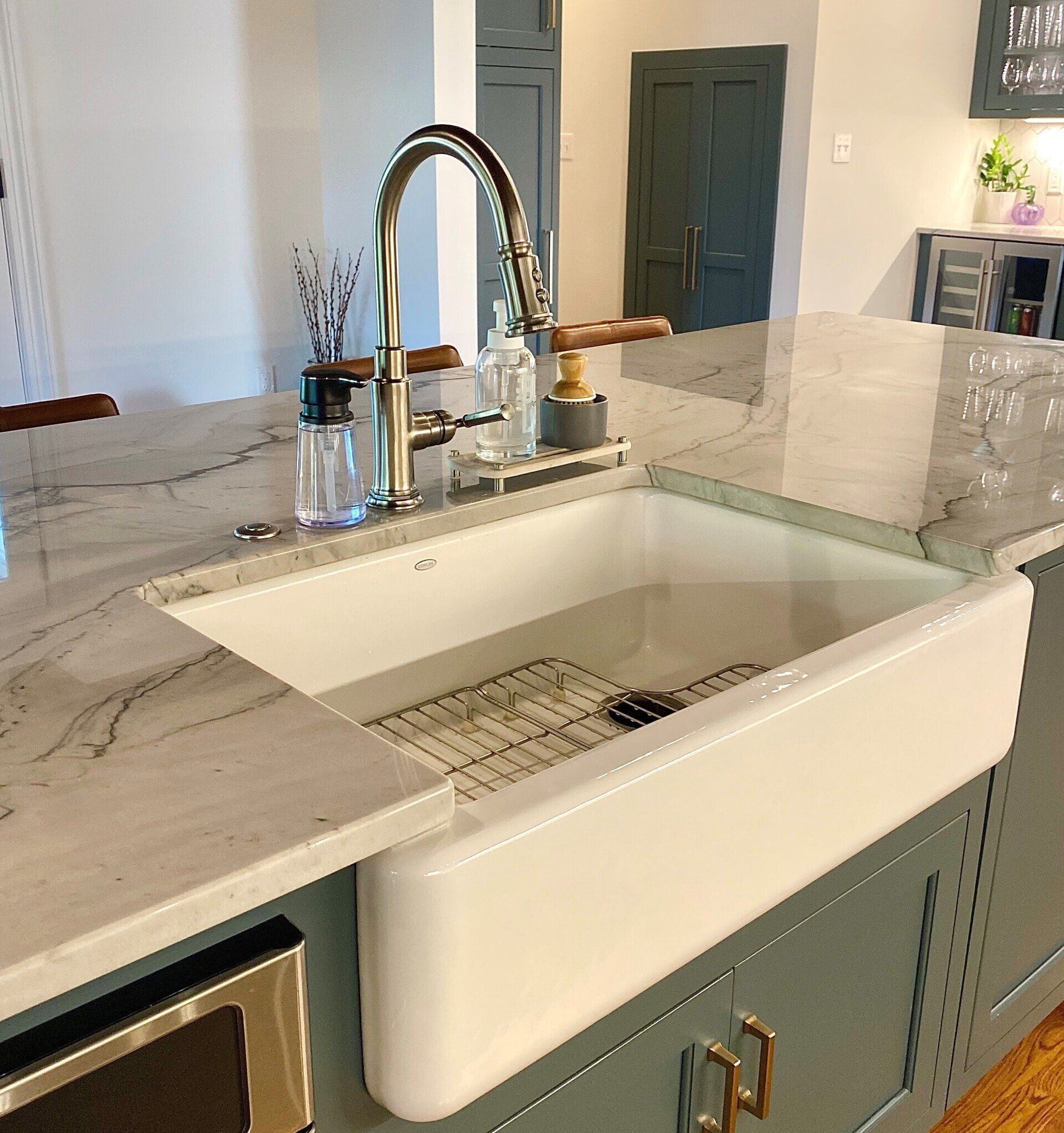 a kitchen with a white sink and a stainless steel faucet