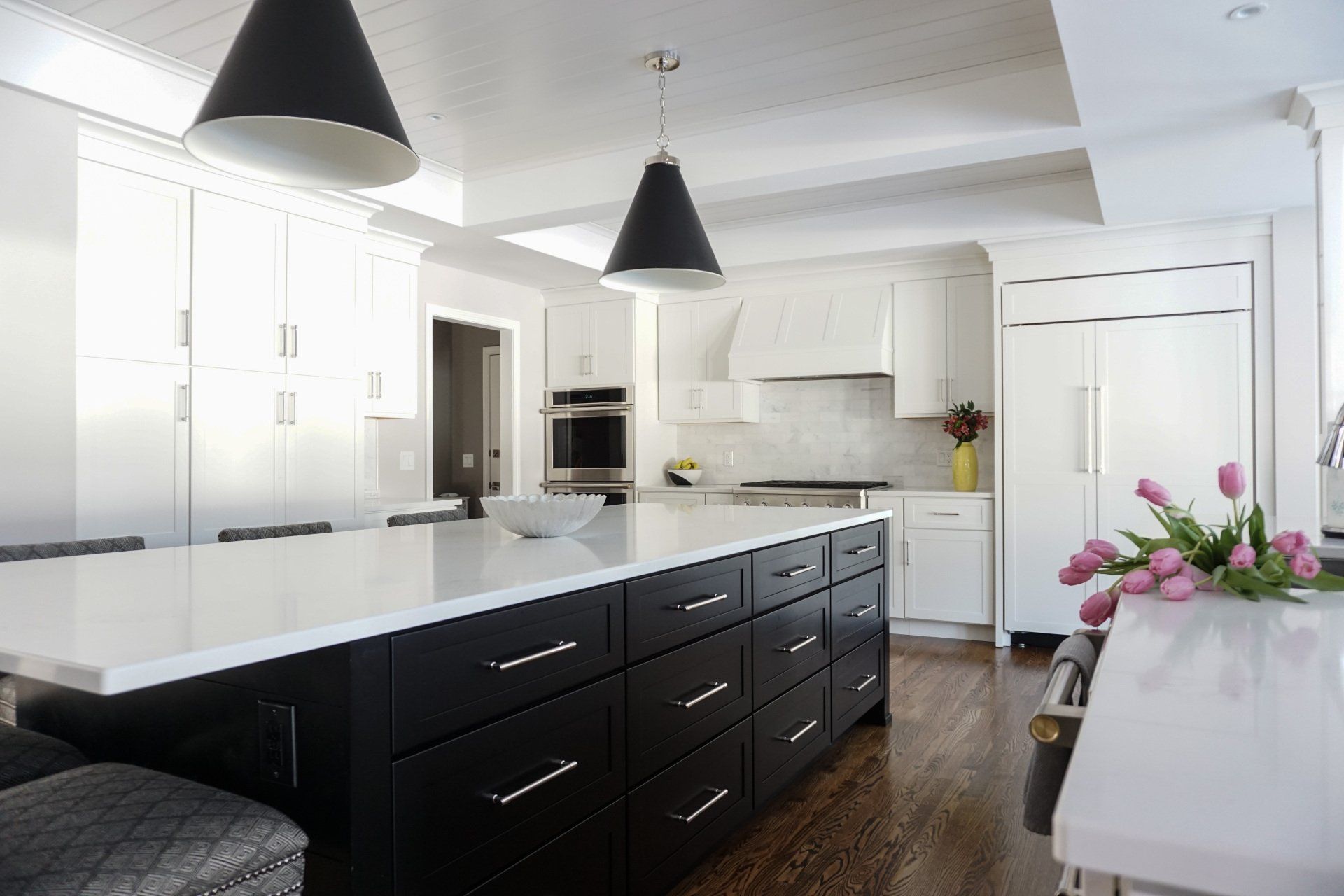 a kitchen with black cabinets and white counter tops