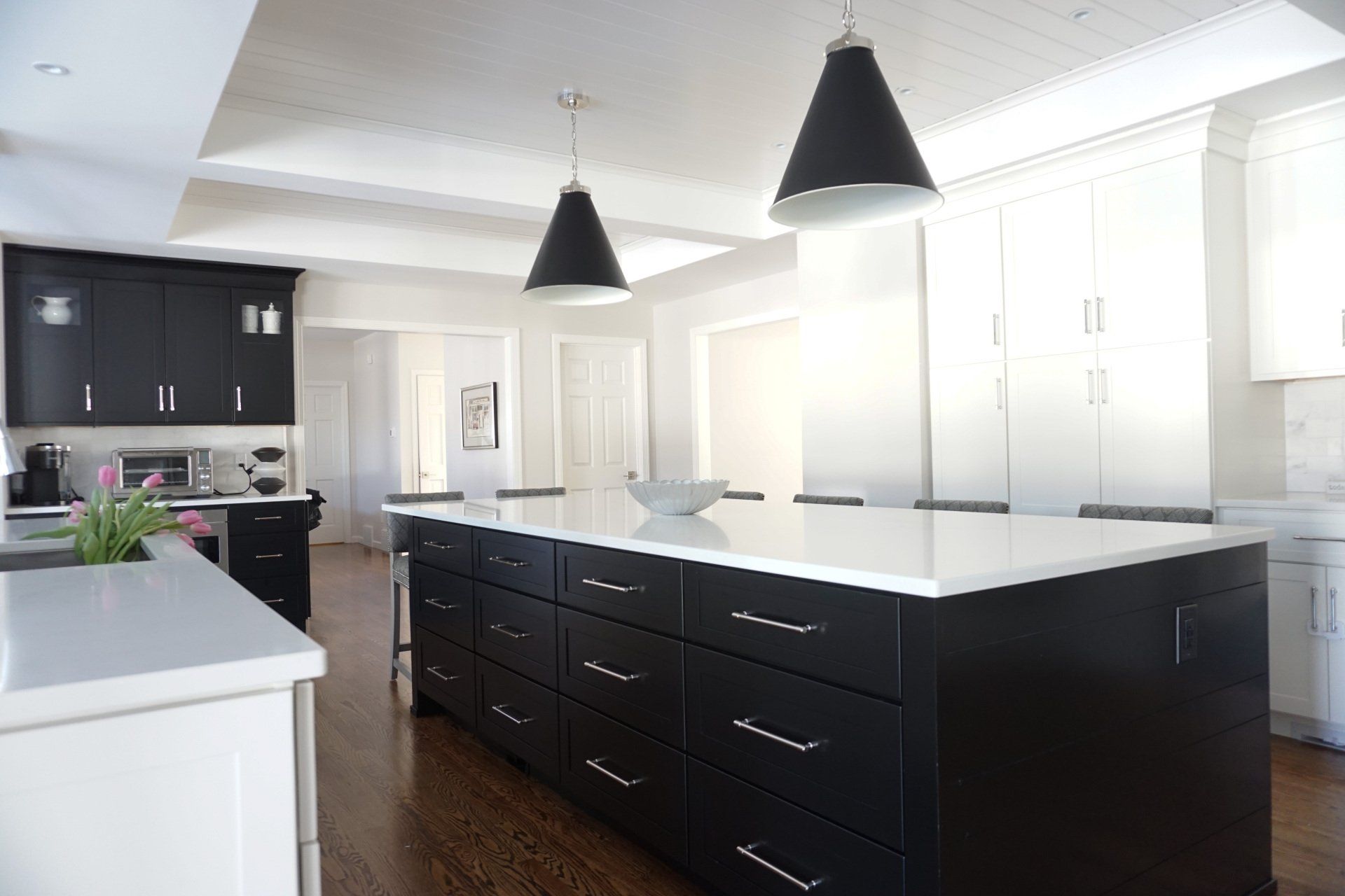 a kitchen with black cabinets and white counter tops