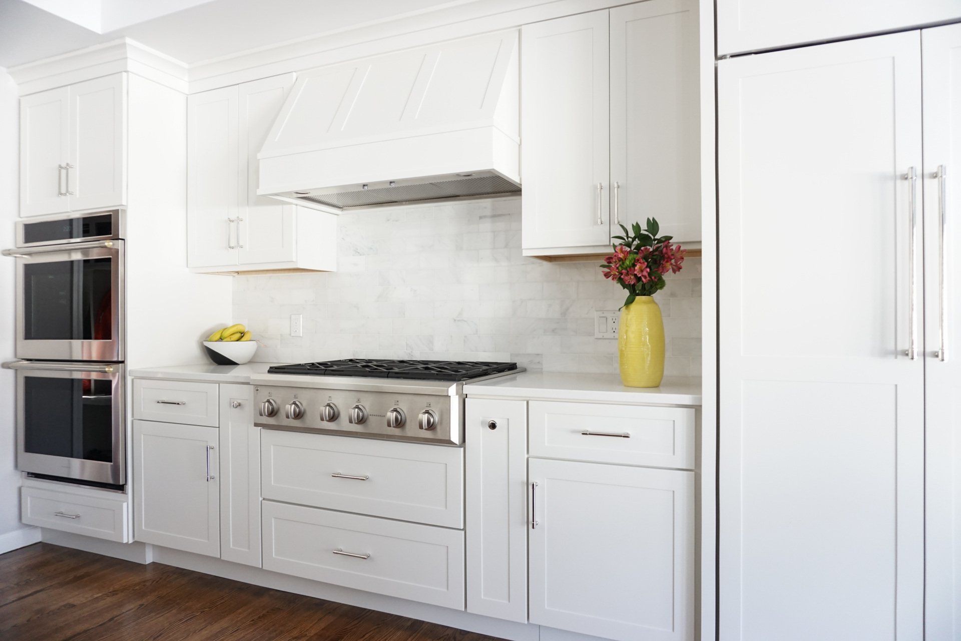 a kitchen with white cabinets and stainless steel appliances