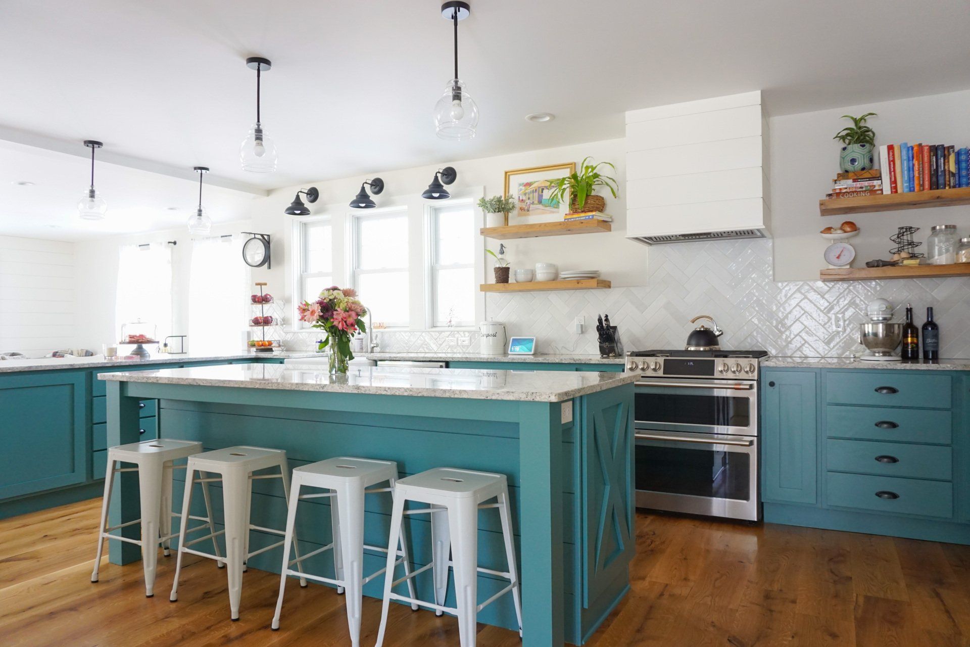 a kitchen with blue cabinets and white stools