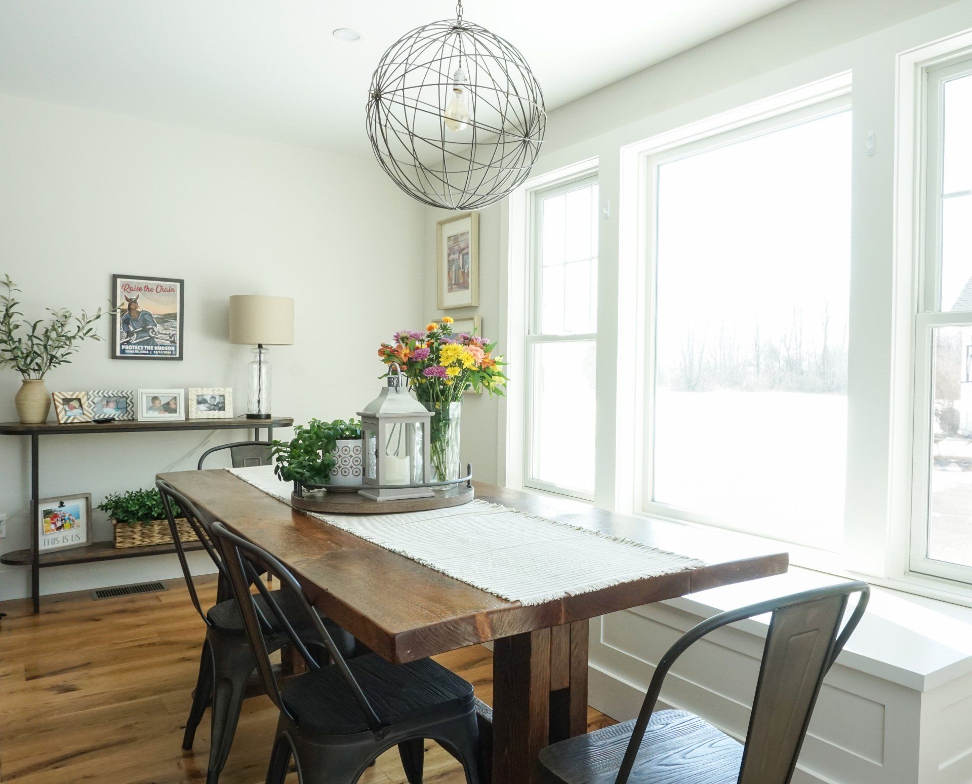 A dining room with a wooden table and chairs and a window seat.
