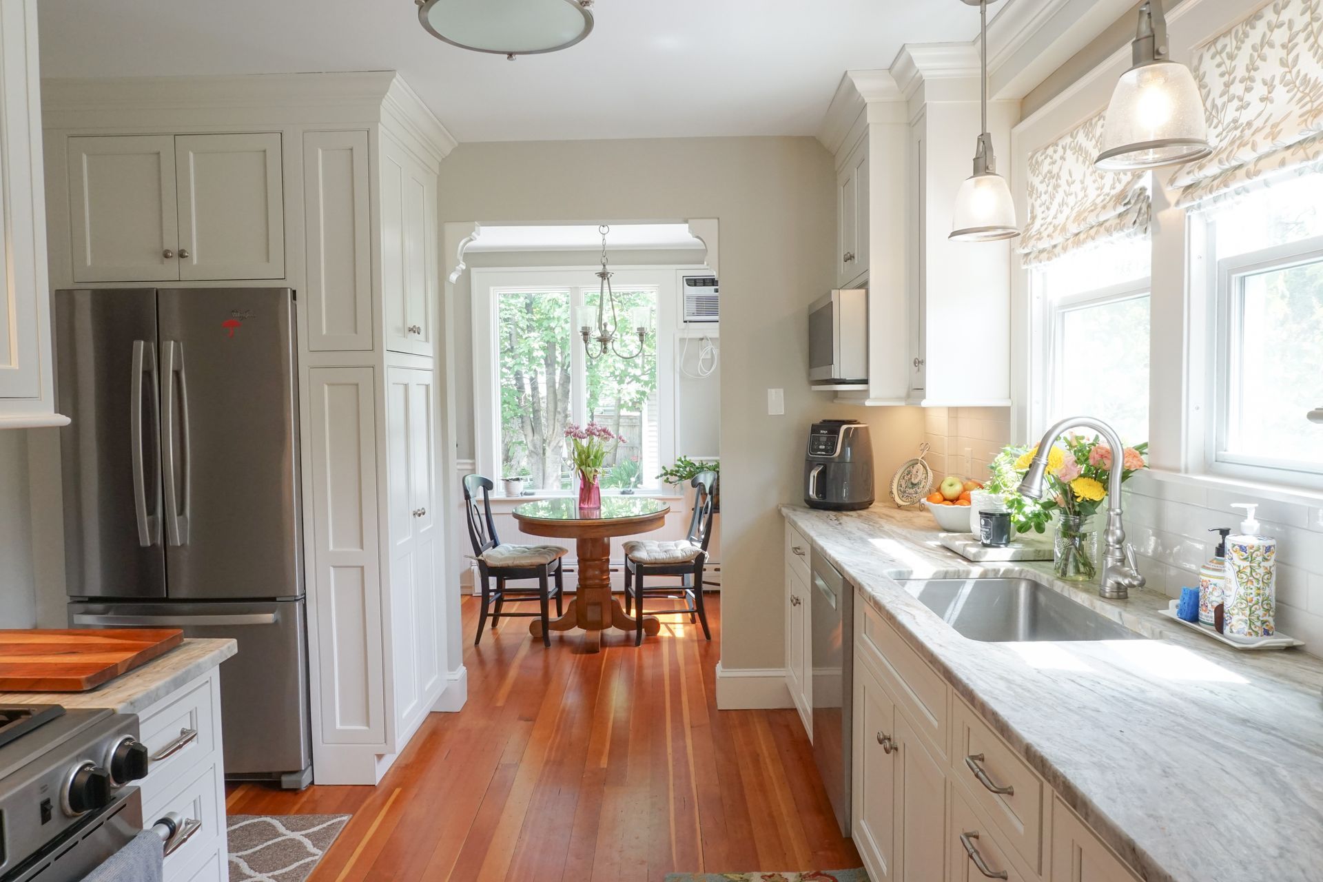 a kitchen with white cabinets and a stainless steel refrigerator