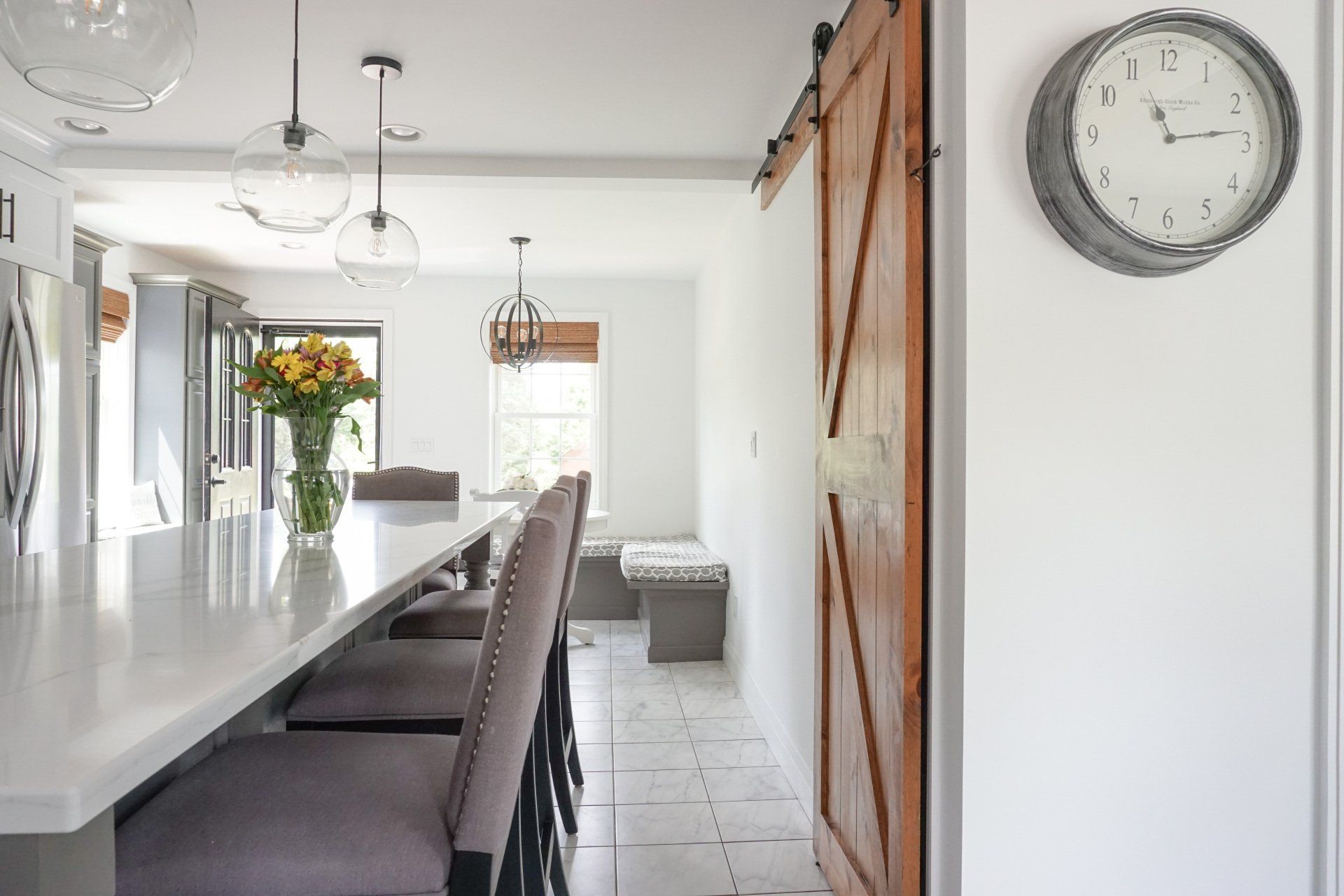 a kitchen with a sliding barn door and a clock on the wall