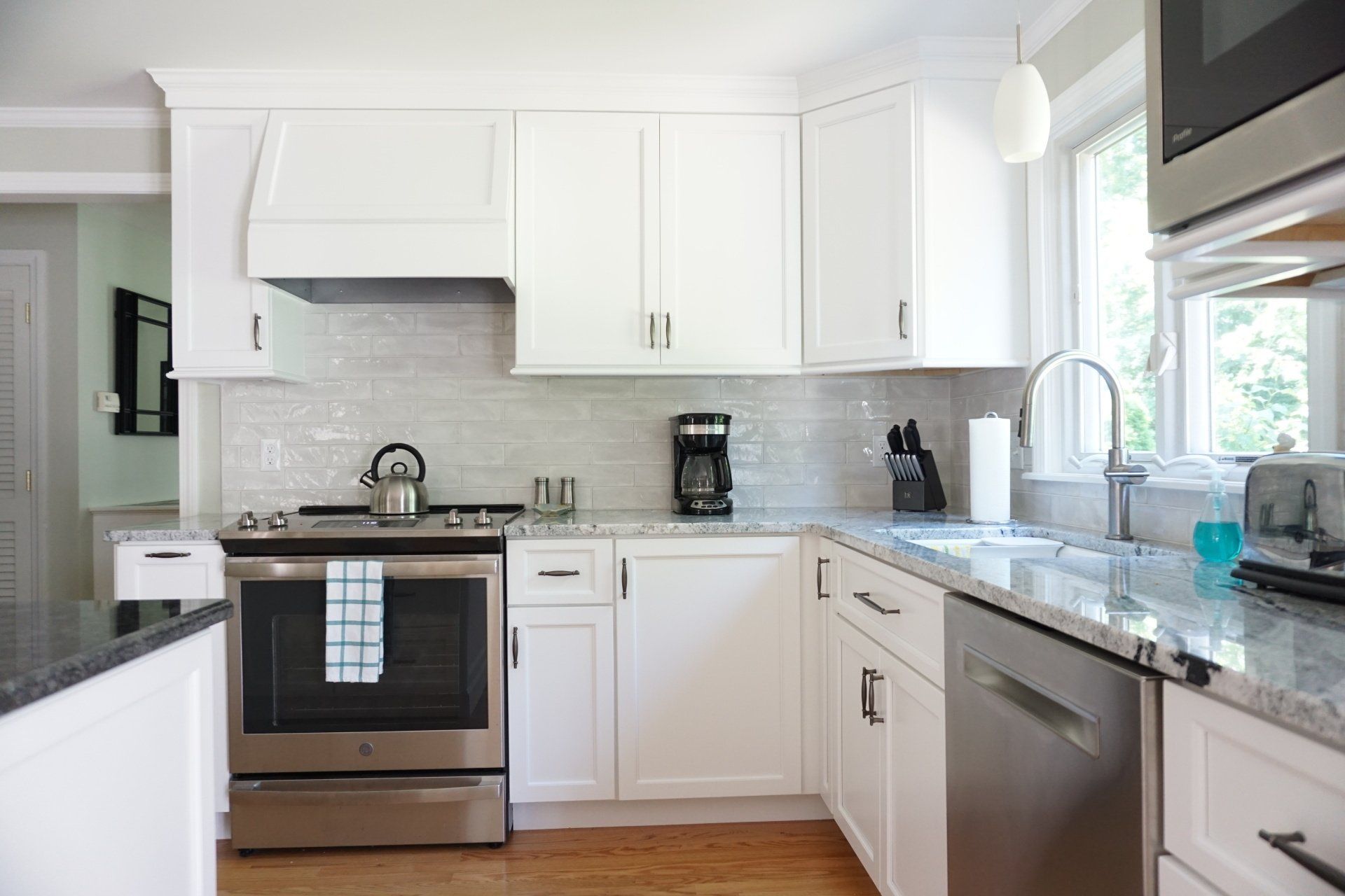a kitchen with white cabinets and stainless steel appliances