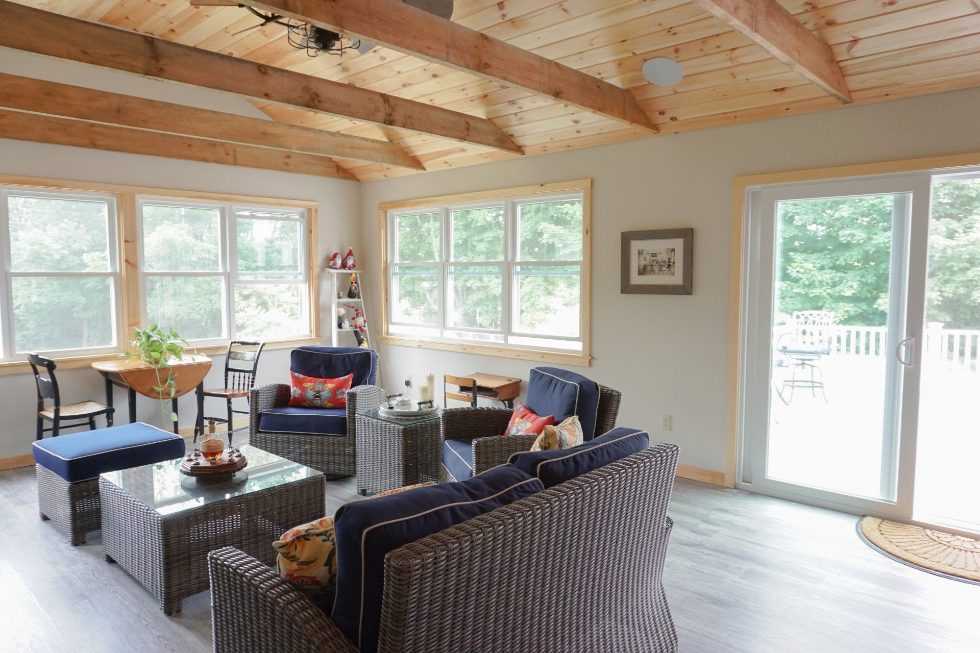 A living room with a couch , chairs , coffee table and sliding glass doors.