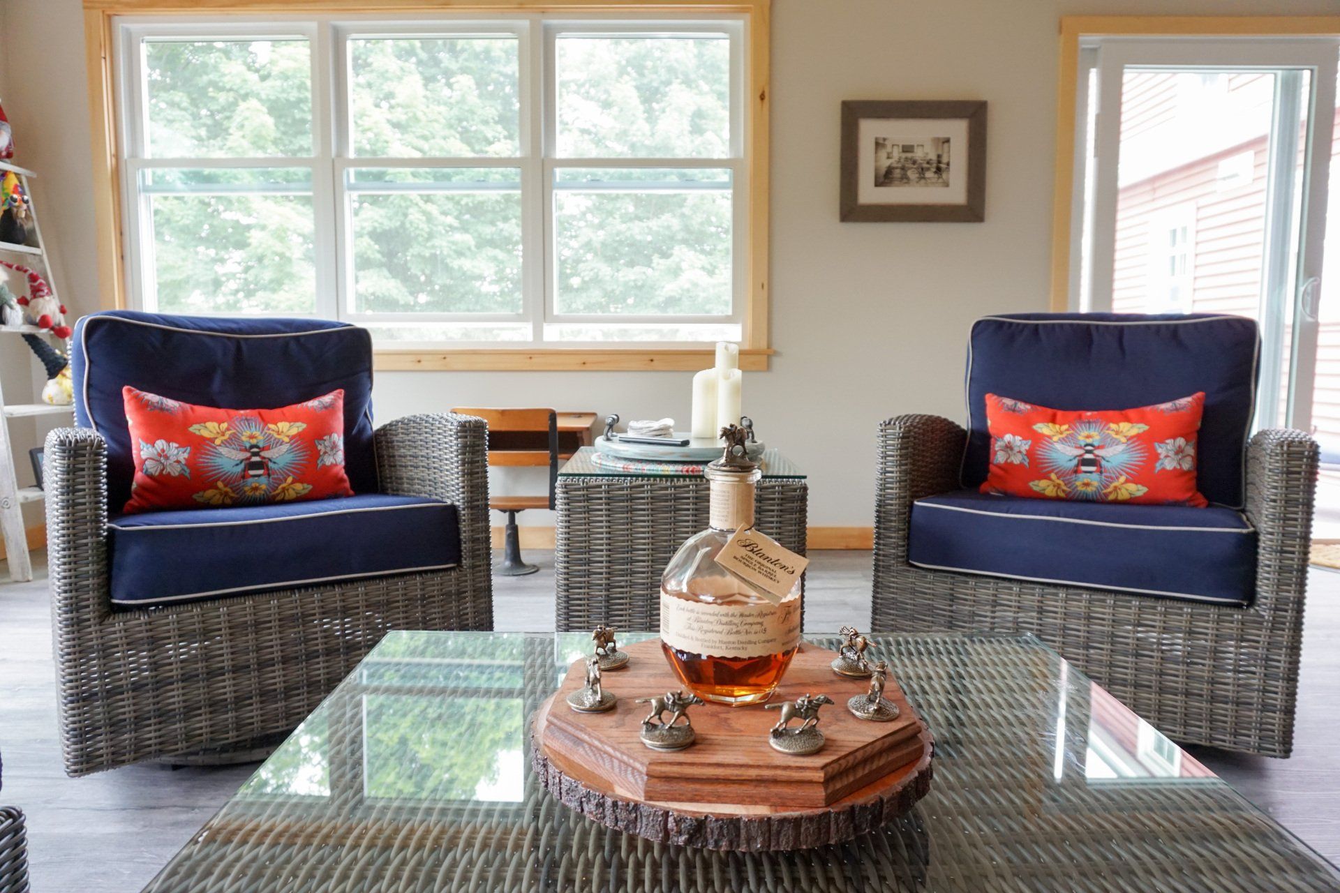 A living room with two chairs and a coffee table with a bottle of whiskey on it.