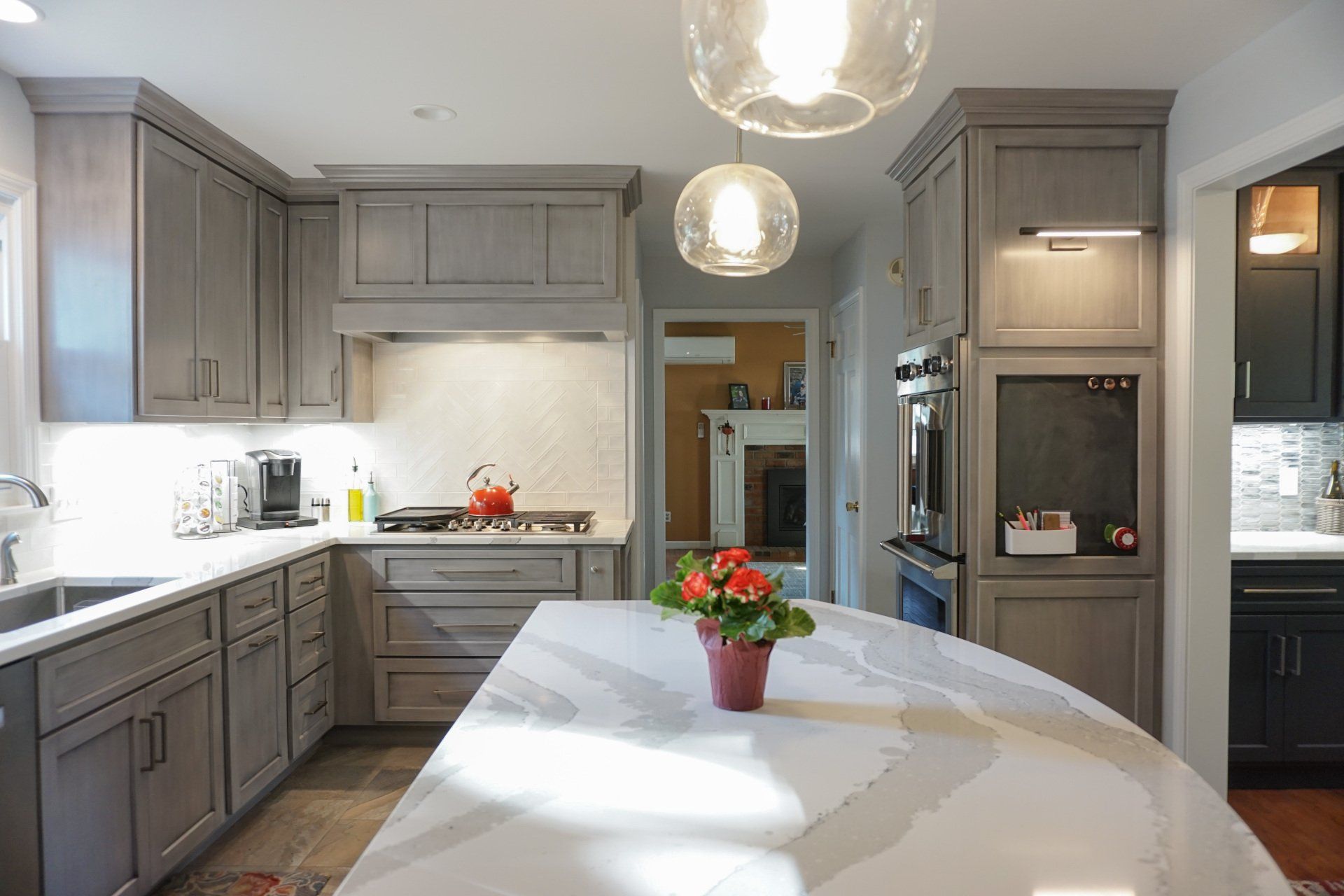 a kitchen with gray cabinets and white counter tops
