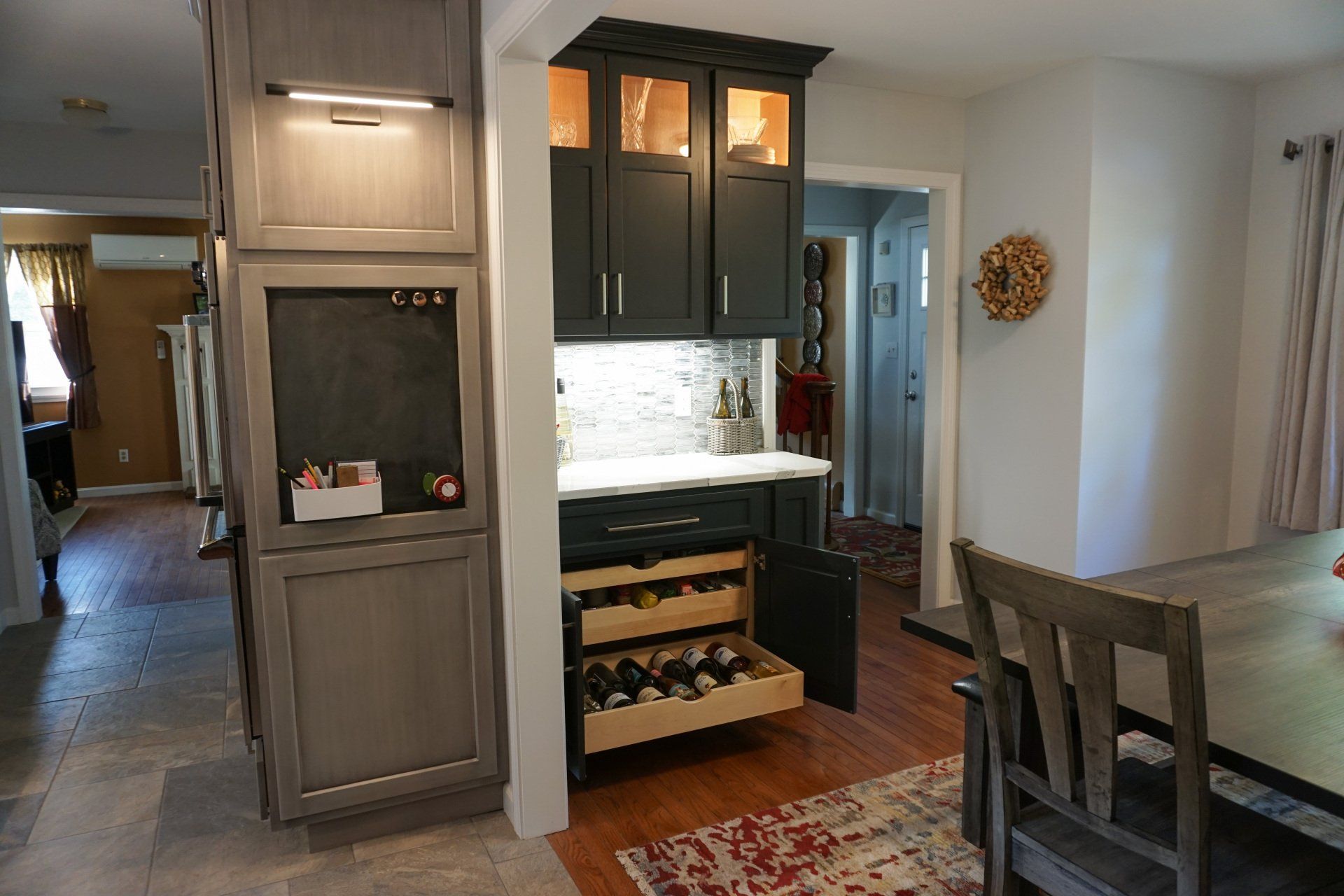 a kitchen with a drawer full of wine bottles
